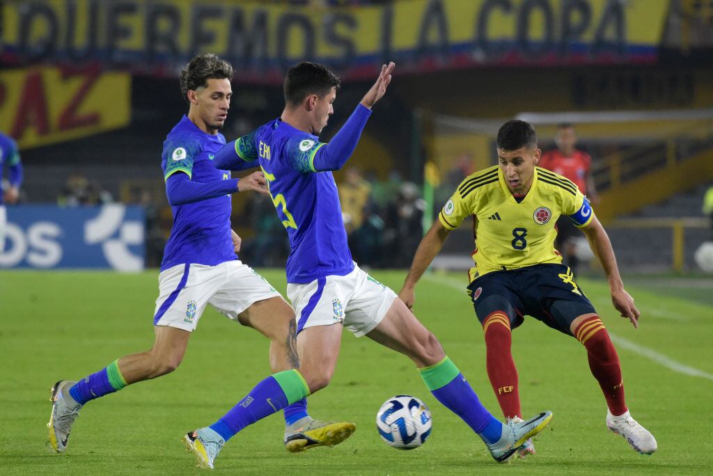 BOGOTA, COLOMBIA - FEBRUARY 09: Gustavo Puerta of Colombia fights for the ball with Jean Cameiro and Marlon Gomes of Brazil during a South American U20 Championship match between Colombia and Brazil at Estadio El Campín on February 09, 2023 in Bogota, Colombia. (Photo by Guillermo Legaria Schweizer/Getty Images)