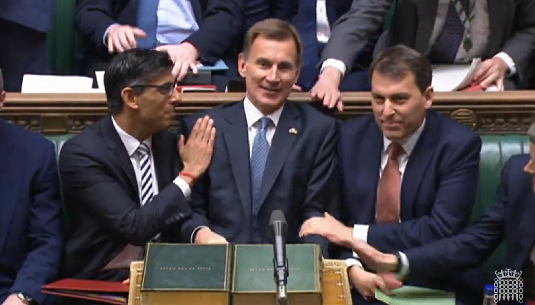 El primer ministro británico, Rishi Sunak (izq), felicita al ministro de Finanzas, Jeremy Hunt (cen) tras la presentación del nuevo plan fiscal para el Reino Unido.
 (Photo by House of Commons/PA Images via Getty Images)