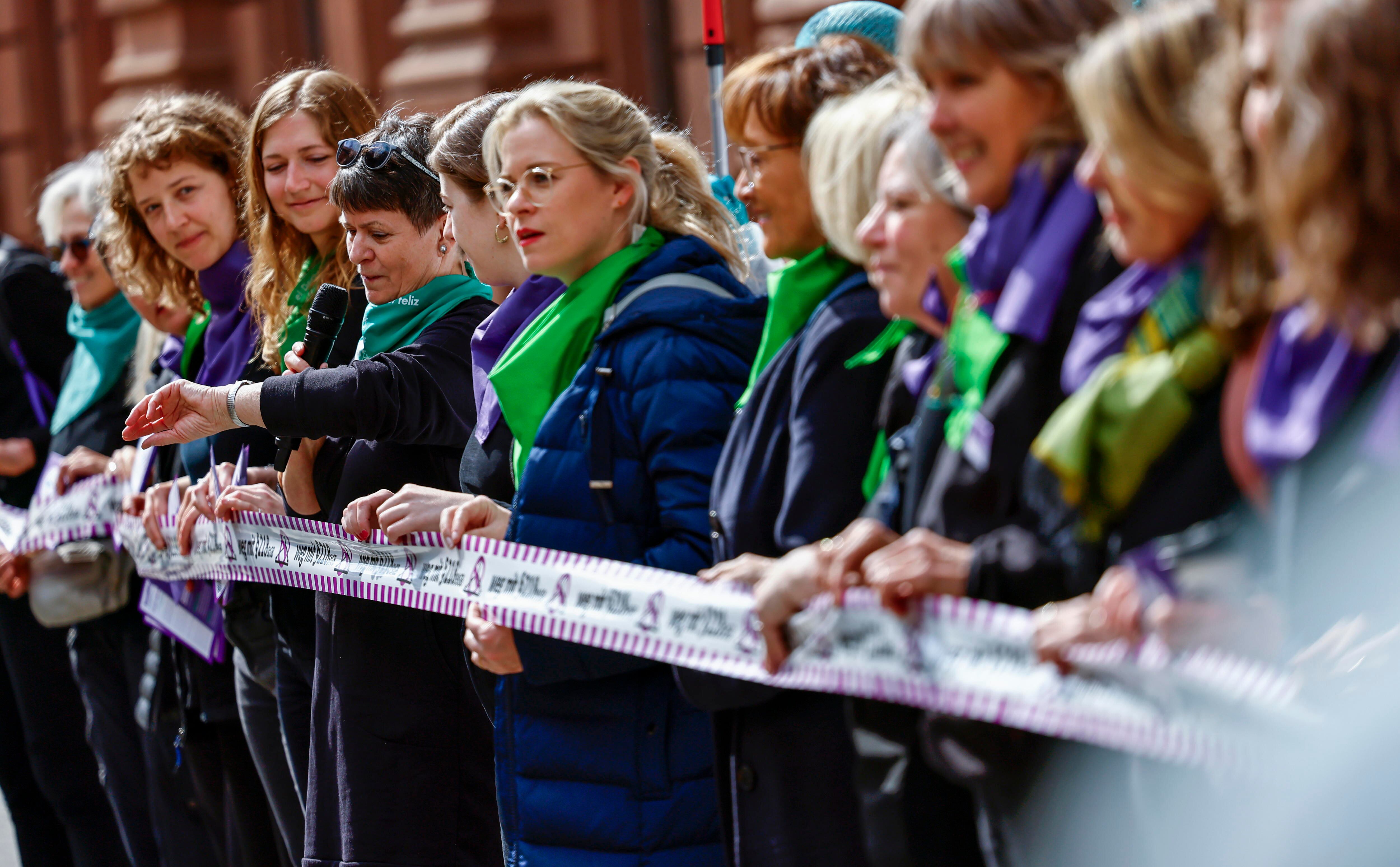Berlin (Germany), 15/04/2024.- Activists take part at a symbolically crossing out paragraph 218 abortion from the penal code with the color purple during a flash mob in Berlin, Germany, 15 April 2024. The action was organized by the Alliance for Sexual Self-Determination under the slogan "Legal, simple, fair - for a new regulation of abortion in Germany!". A commission appointed by the German government has recommended officially legalizing abortion in the first 12 weeks of pregnancy. That legal framework is around 30 years old and has long been criticized. Germany's governing coalition of the Social Democrats (SPD), Greens, and Free Democrats (FDP) is revisiting the issue and wants to liberalize the abortion law. (Alemania) EFE/EPA/HANNIBAL HANSCHKE