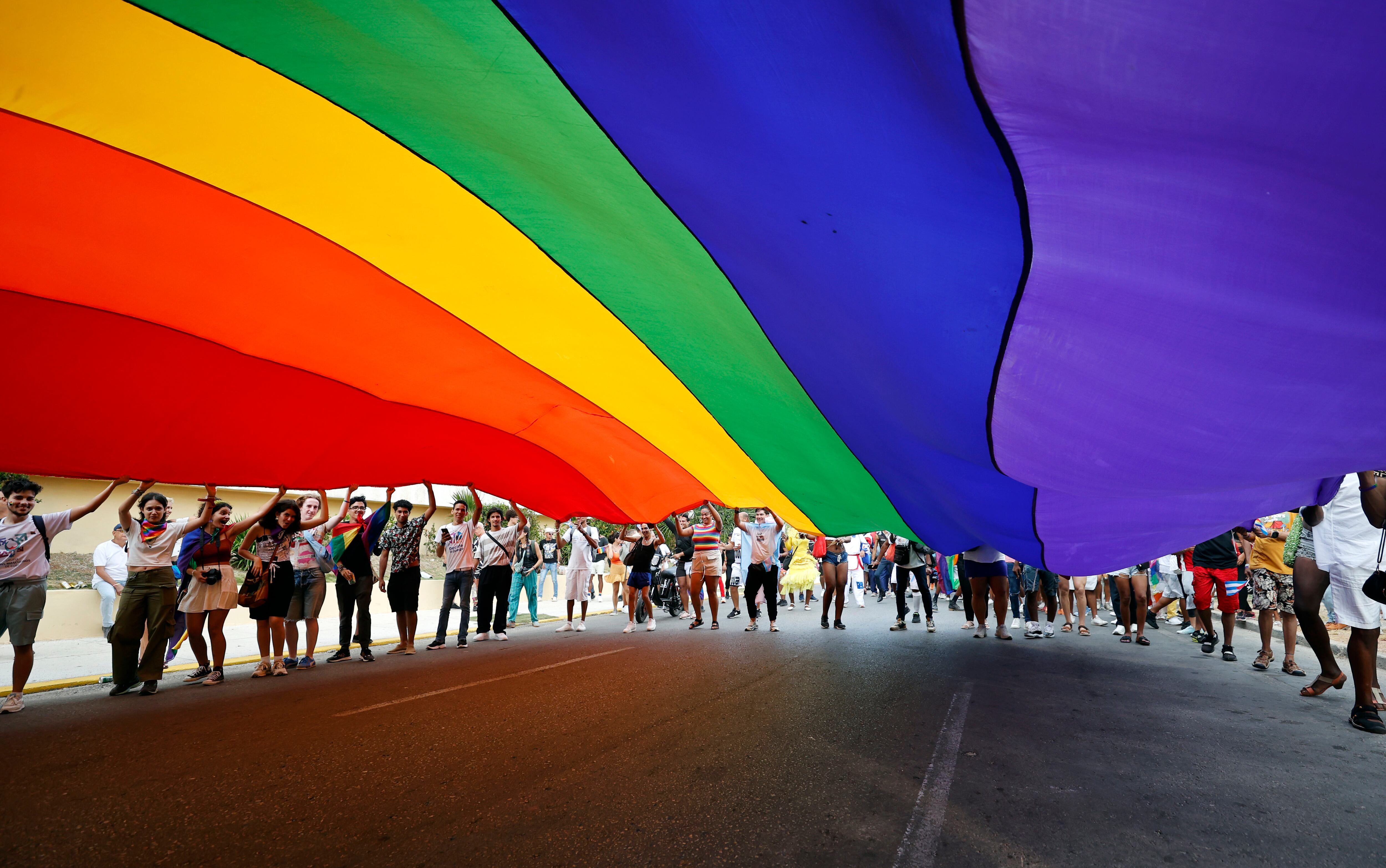 Fotografía de archivo del 10 de Mayo de 2025 de personas sosteniendo una bandera en una marcha por el Día Internacional del Orgullo LGTBI, en La Habana (Cuba). EFE/ Ernesto Mastrascusa/ARCHIVO