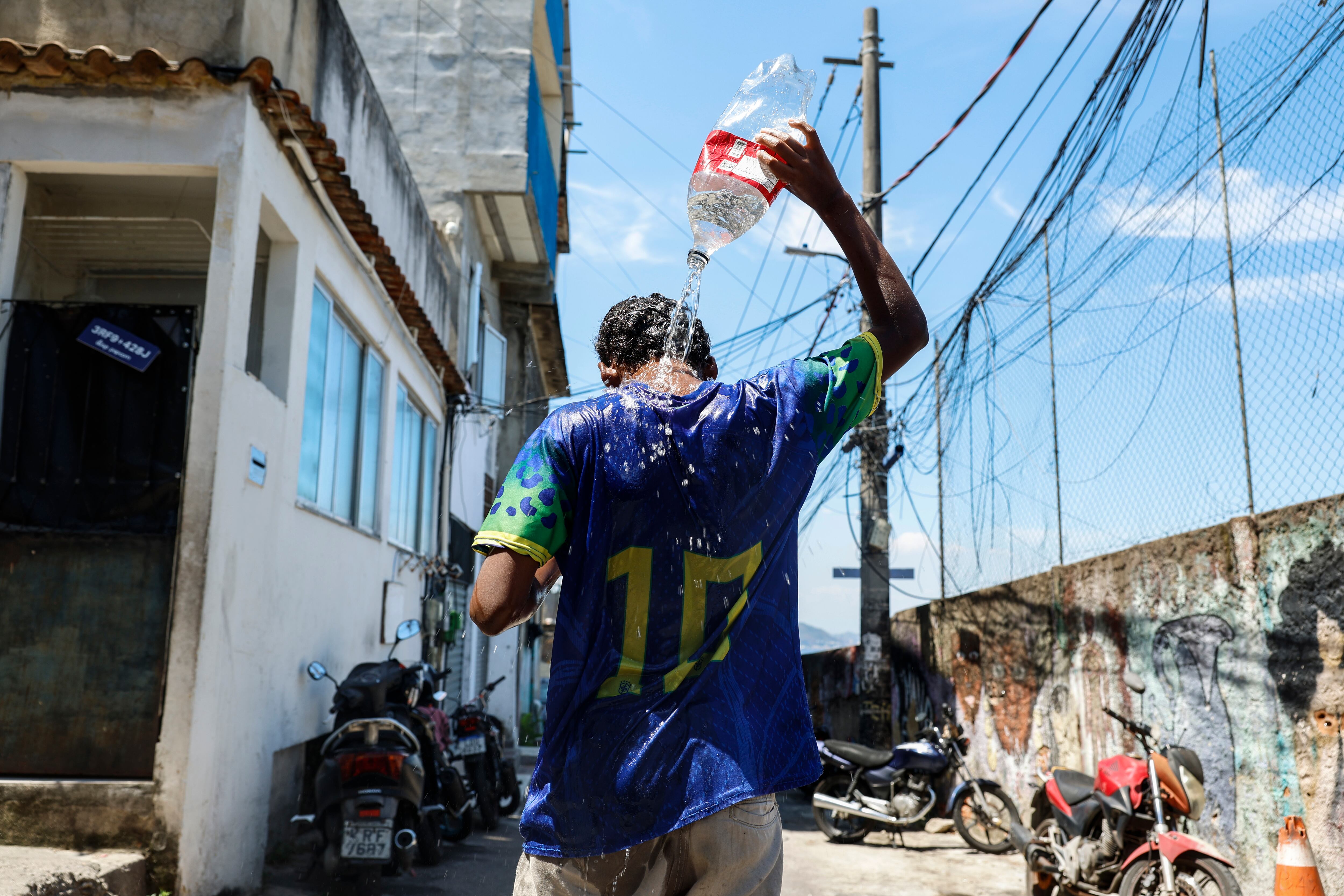 -FOTOSDELDÍA- AME1712. RÍO DE JANEIRO (BRASIL), 20/02/2025.- Elias Marques Felix Moura, de 12 años, se baña en las calles de la favela de Tavares Bastos este jueves, en Río de Janeiro (Brasil). La ola de calor en Rio de Janeiro ha azotado la ciudad con temperaturas de 40 grados y sensación térmica de 55 grados. EFE/ Antonio Lacerda.