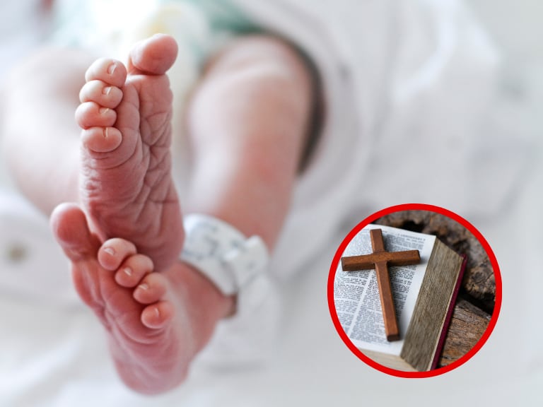Pies de un bebé recién nacido y una biblia con un crucifijo encima. (Foto: Getty Images)