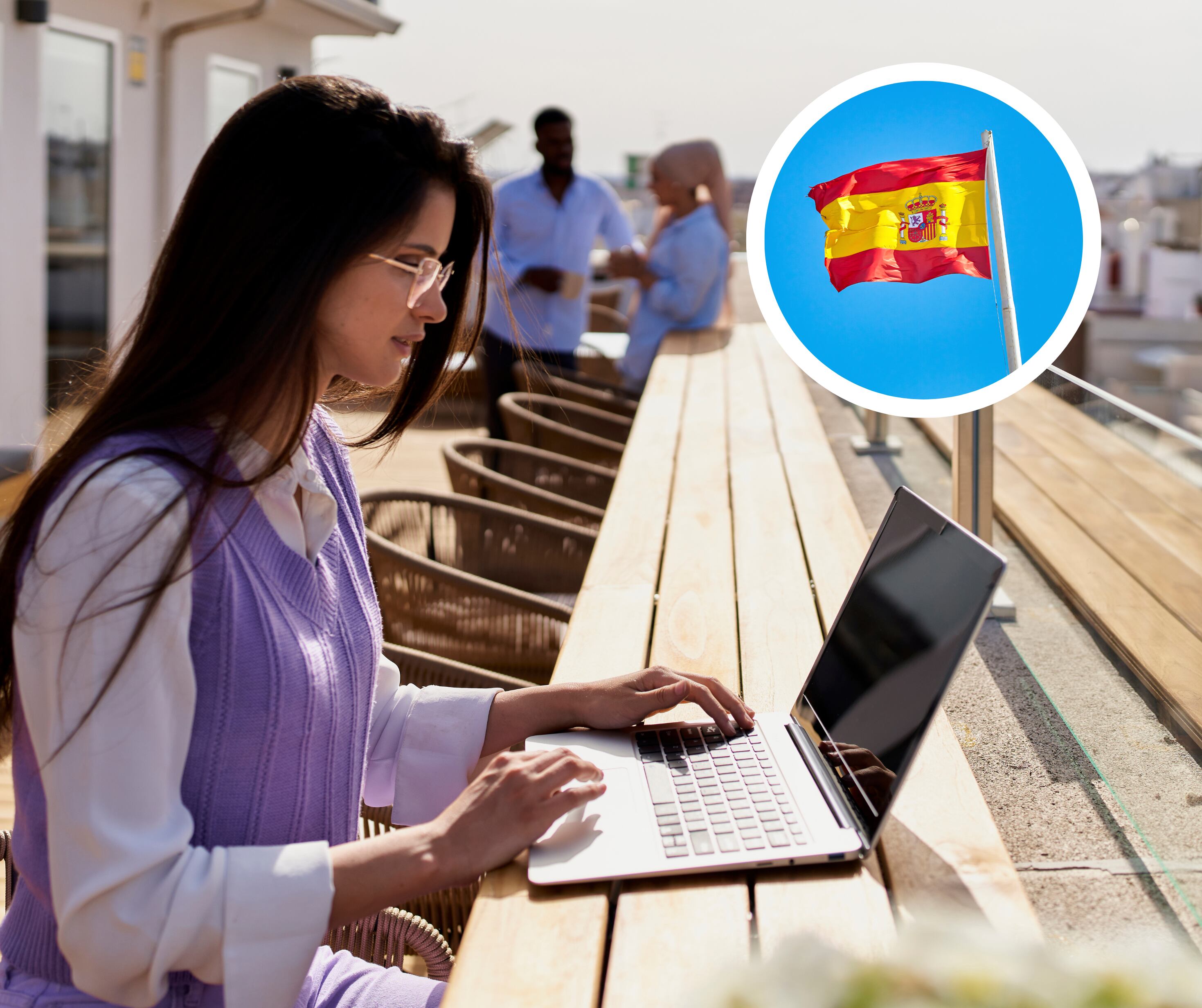 Mujer trabajando desde su computadora desde un espacio abierto y de fondo la bandera de España (Foto vía Getty Images)