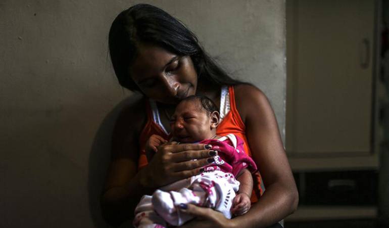 Una mujer de Brasil sostiene a su hija, quien hace parte de la lista de niños que nacieron con microcefalia al haberse visto expuestos al zika.