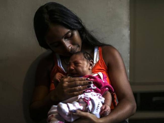 Una mujer de Brasil sostiene a su hija, quien hace parte de la lista de niños que nacieron con microcefalia al haberse visto expuestos al zika.