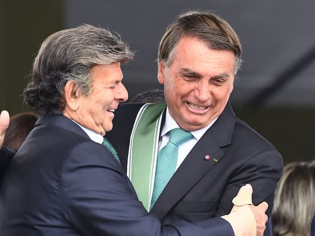 Brazilian President Jair Bolsonaro (R) and the President of the Supreme Court, Luiz Fux, greet each other during the Brazilian Army Day celebration at the Army Headquarters in Brasilia, on April 19, 2022 (Photo by EVARISTO SA / AFP)