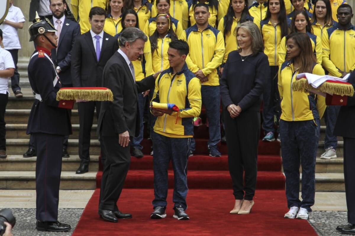 Jossimar Calvo recibe por parte del presidente la bandera de Colombia, para que se portada en la inauguración del os Juegos Olímpicos. 