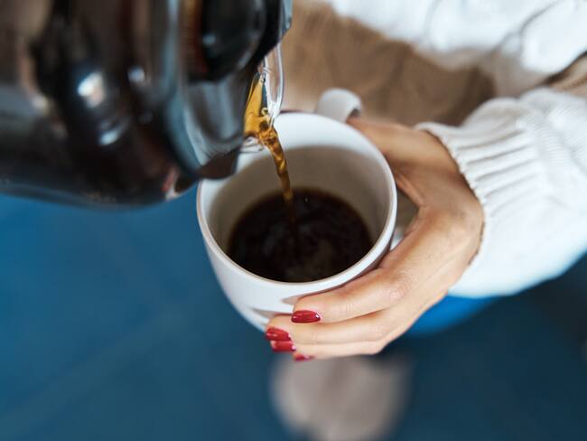 Persona sirviendo una taza de café / Foto: GettyImages