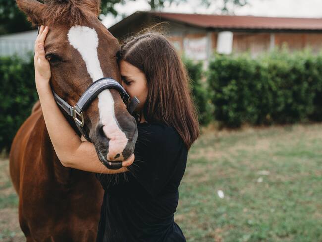 Mujer abrazando a un caballo (Foto vía Getty Images)