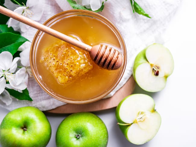 Jewish holiday Rosh Hashanah background with honey and apples // foto de referencia, Getty Images