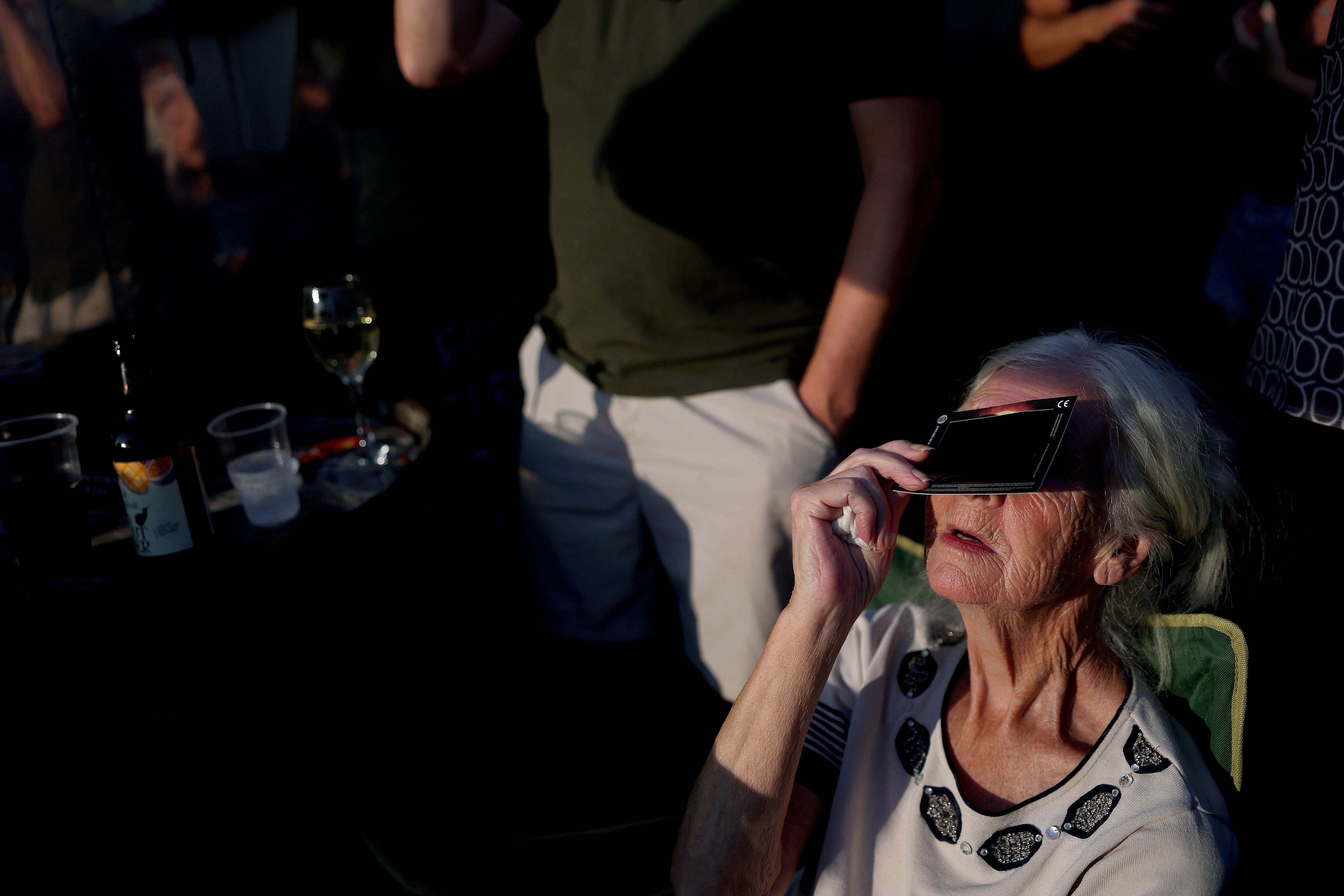 Personas observan el eclipse solar parcial desde The Gresley Arms en Stoke-on-Trent, Inglaterra. (Photo by Carl Recine/Getty Images)