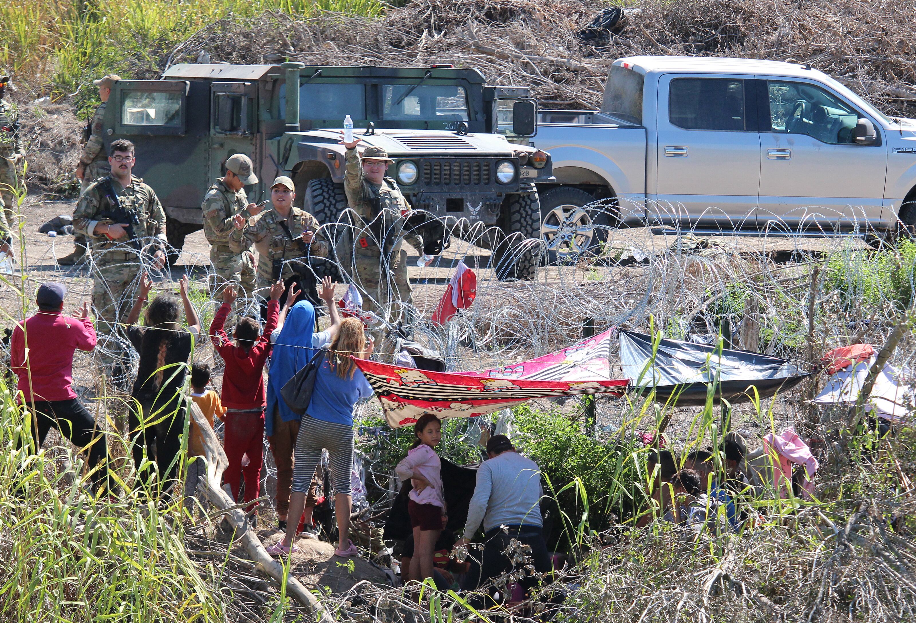 MEX6437. MATAMOROS (MÉXICO),25/09/2023.- Migrantes son retenidos por La Guardia Nacional estadounidense al cruzar el Río Bravo para intentar ingresar a Estados Unidos hoy, en Matamoros (México). La Guardia Nacional estadounidense retienen a migrantes venezolanos que cruzaron el fronterizo río Bravo (río Grande en EE.UU.) en el norte de México, dejándolos con raciones de agua limitada y sin comida por casi un día, denunciaron este lunes migrantes y activistas en la ciudad mexicana de Matamoros, estado de Tamaulipas. EFE/Abrahan Pineda-Jacome