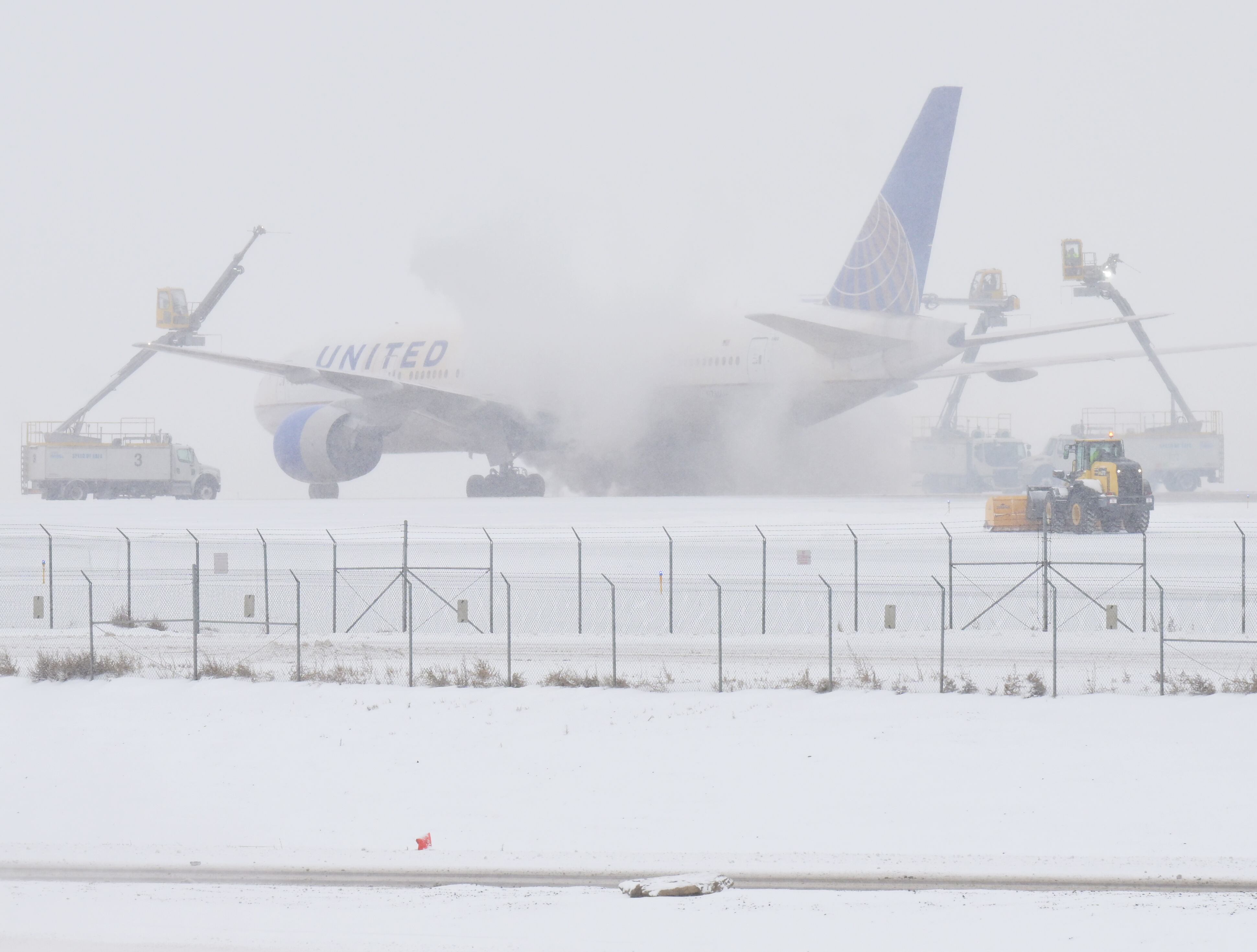 DENVER, COLORADO - JANUARY 15: Crews work to deice an airplane at Denver International Airport in Denver, Colorado on January 15, 2024. Over 320 flights have been canceled because of a winter storm that his the airport with snow and  freezing temperatures. (Photo by RJ Sangosti/MediaNews Group/The Denver Post via Getty Images)