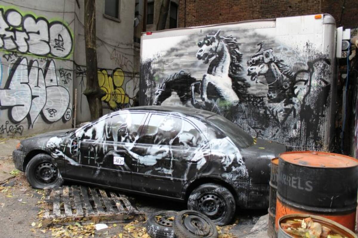 Fotografía de este 11 de octubre de 2013 que muestra a un automóvil con grafitis que hizo Banksy en Lower East Side, Nueva York (EE.UU.)