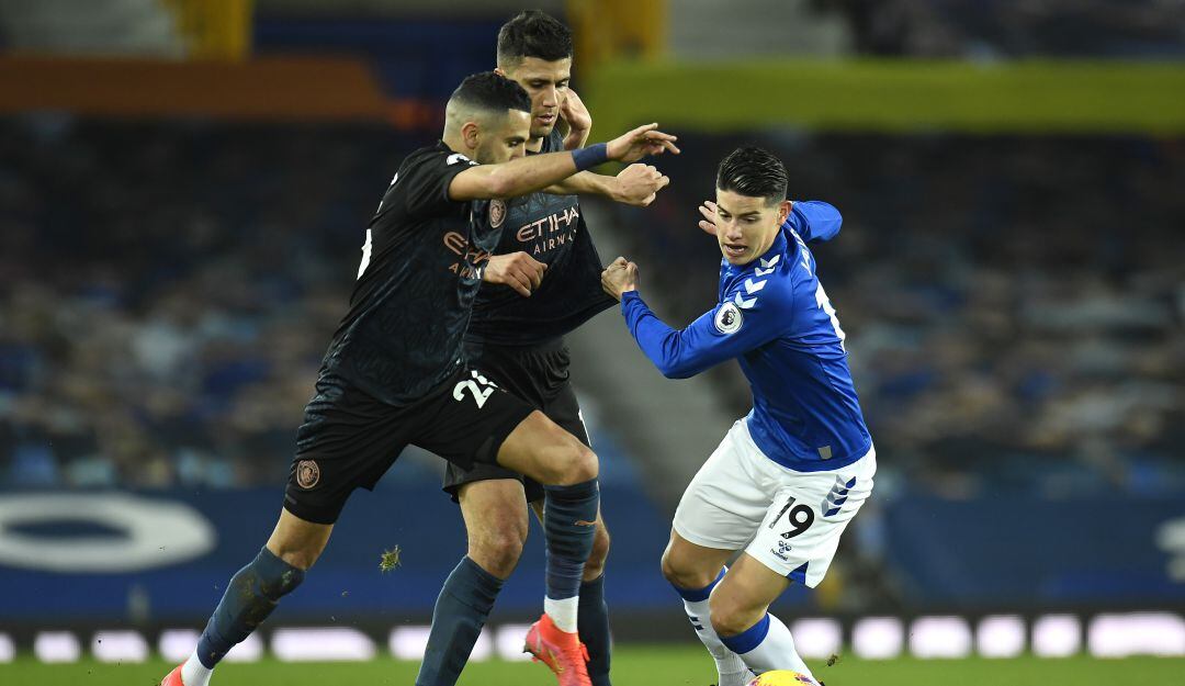 James Rodríguez intenta disputar una pelota ante el acoso de dos jugadores del Manchester City.