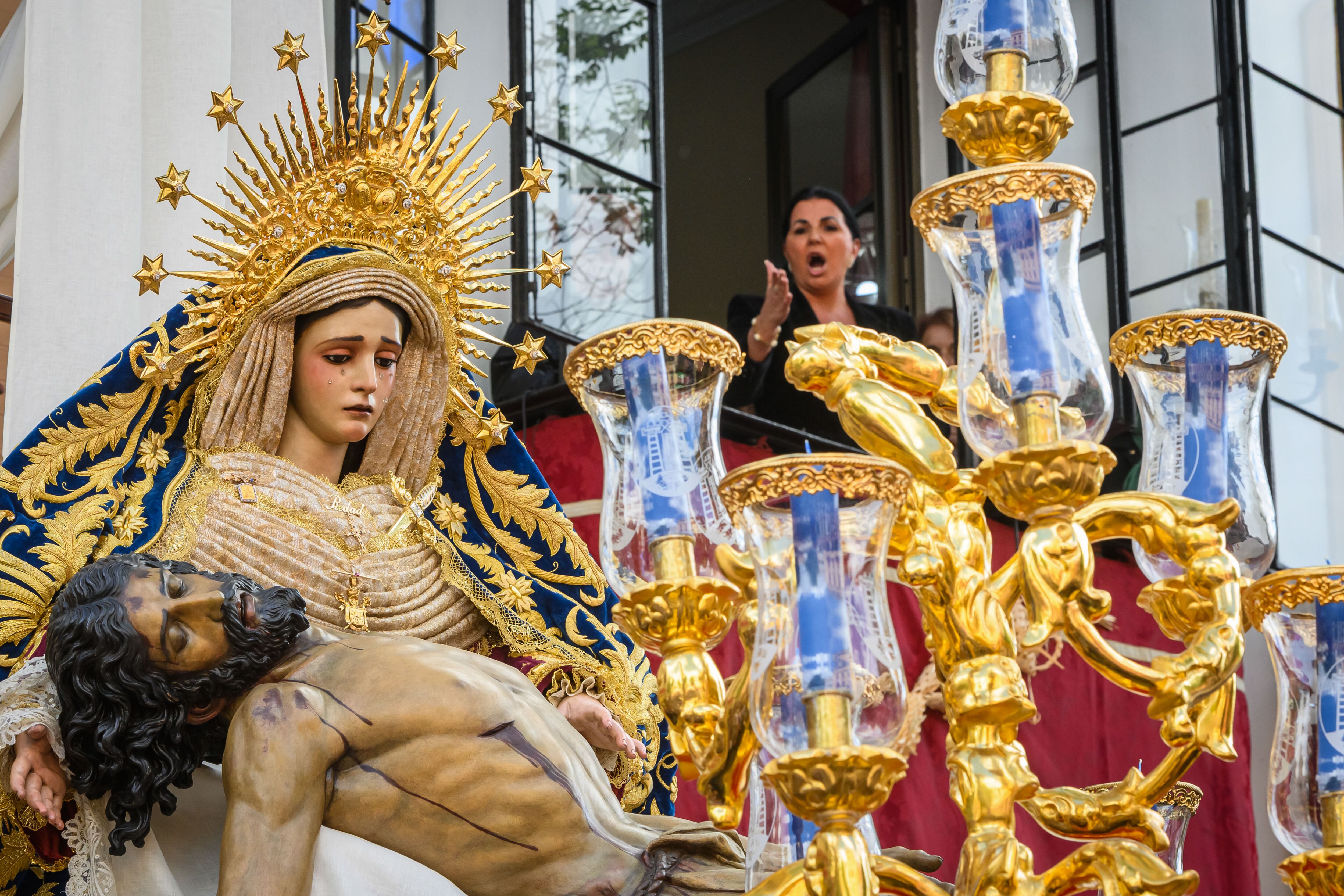 SEVILLA. 16/04/2025. - Una mujer canta una saeta al Santísimo Cristo de la Misericordia y Nuestra Señora de la Piedad desde un balcón a la salida de la Hermandad de El Baratillo, este Miércoles Santo en Sevilla. EFE/ Raúl Caro.