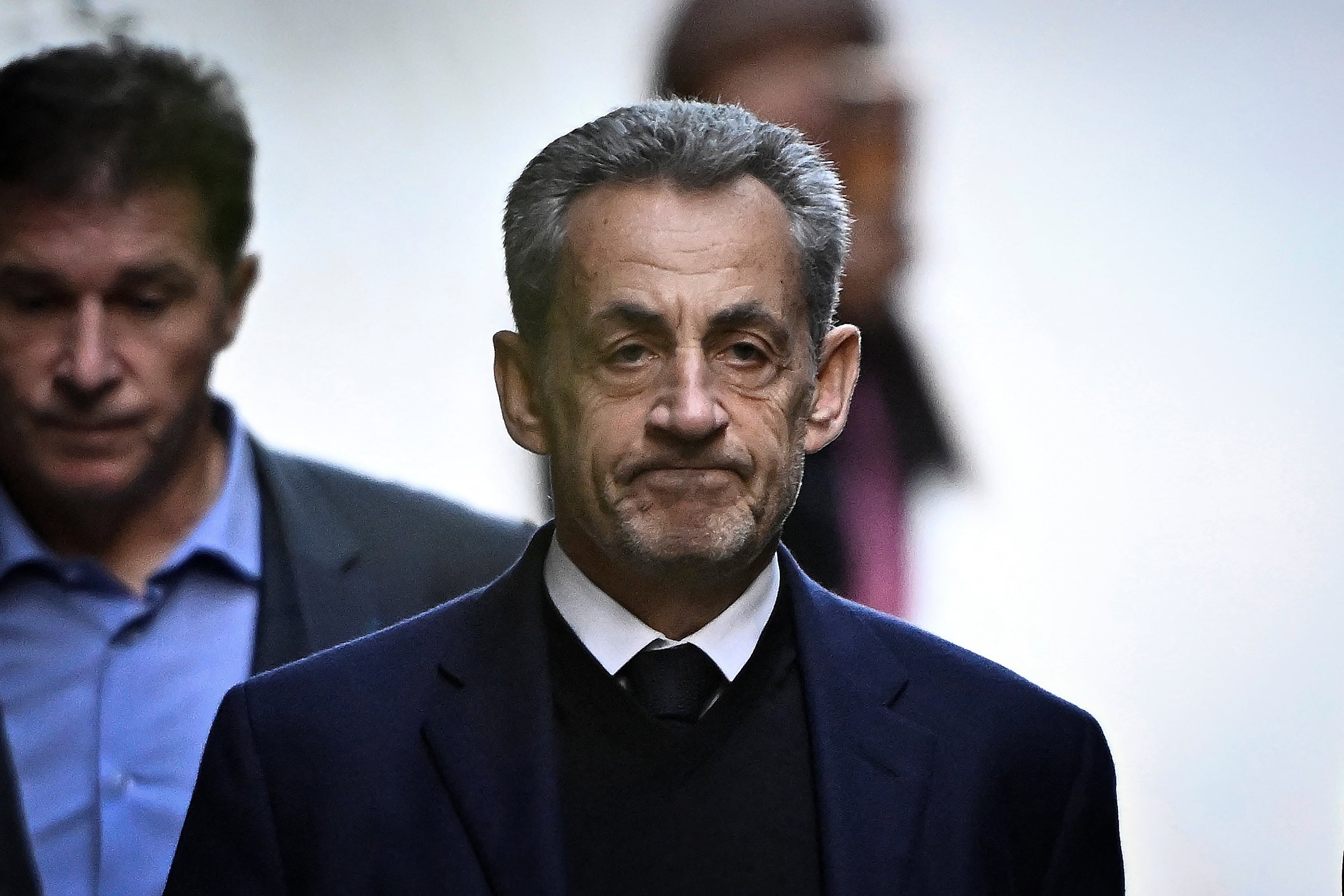 (FILES) France's former president Nicolas Sarkozy leaves his residence to present himself to La Sante Prison for incarceration on a five-year prison sentence after being convicted of criminal conspiracy over a plan for late Libyan dictator Moamer Kadhafi to fund his 2007 electoral campaign, in Paris, on October 21, 2025. Less than two weeks after his release from prison, Nicolas Sarkozy announced on November 21, the release on December 10 of his new book entitled "Journal d'un Prisonnier" (Journal of a prisoner) on his incarceration at Paris' Prison de la Sante. Nicolas Sarkozy was released under judicial supervision on November 10, pending an appeals trial over allegations that he sought Libyan funding. (Photo by JULIEN DE ROSA / AFP)