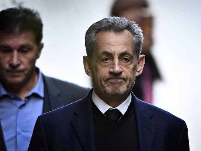 (FILES) France's former president Nicolas Sarkozy leaves his residence to present himself to La Sante Prison for incarceration on a five-year prison sentence after being convicted of criminal conspiracy over a plan for late Libyan dictator Moamer Kadhafi to fund his 2007 electoral campaign, in Paris, on October 21, 2025. Less than two weeks after his release from prison, Nicolas Sarkozy announced on November 21, the release on December 10 of his new book entitled "Journal d'un Prisonnier" (Journal of a prisoner) on his incarceration at Paris' Prison de la Sante. Nicolas Sarkozy was released under judicial supervision on November 10, pending an appeals trial over allegations that he sought Libyan funding. (Photo by JULIEN DE ROSA / AFP)