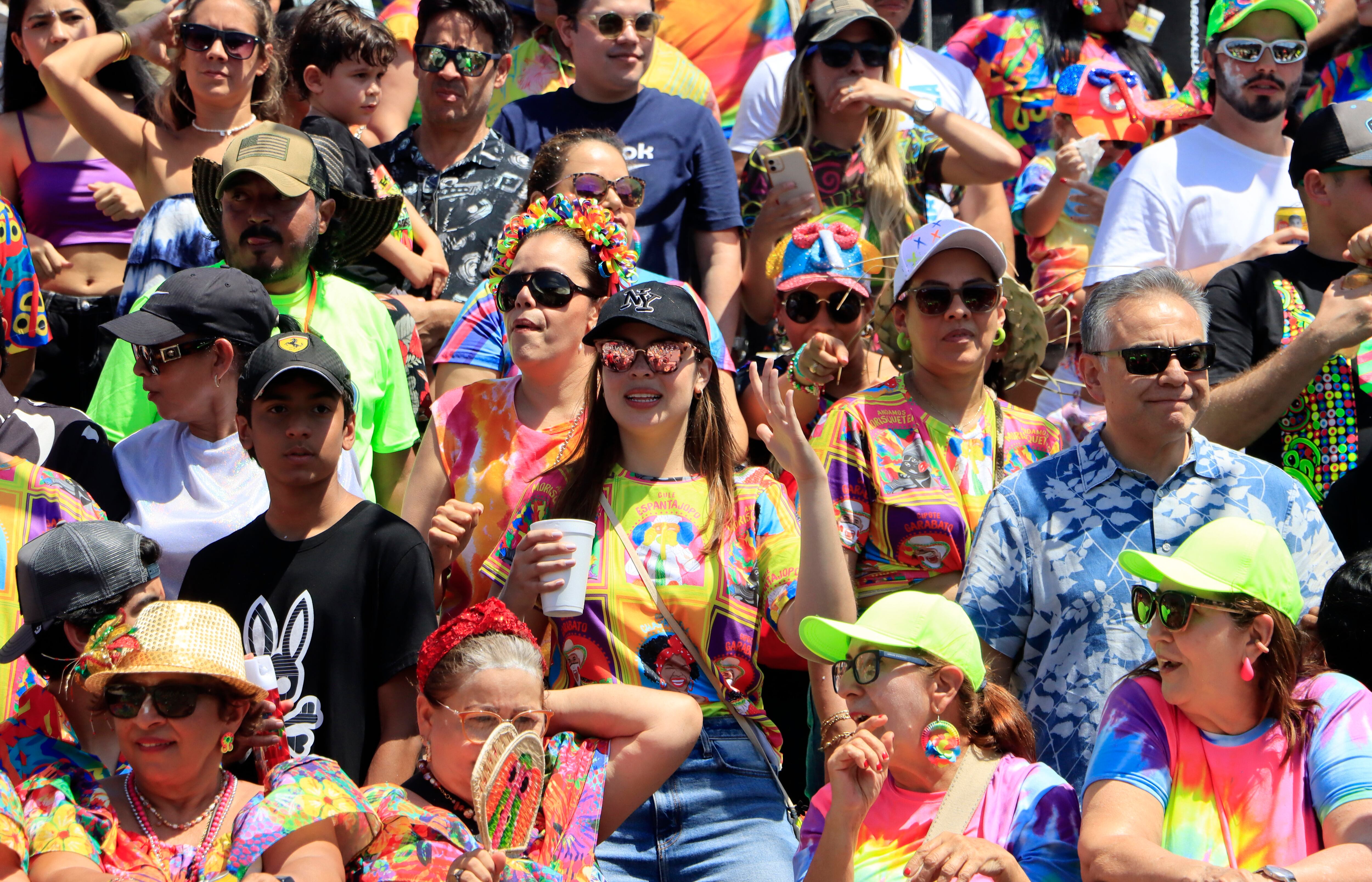 AME8027. BARRANQUILLA (COLOMBIA), 10/02/2024.- Asistentes disfrutan de la tradicional Batalla de Flores, el primer desfile del Carnaval de Barranquilla, hoy, en Barranquilla (Colombia). Con la Batalla de Flores, un desfile de 4 kilómetros en los que 11.000 participantes deleitan a más de 50.000 asistentes que se apostan a lado y lado del Cumbiódromo de la Vía 40, se dio inicio este sábado al Carnaval de Barranquilla, que hace 20 años fue declarado Patrimonio Cultural e Inmaterial de la Humanidad por la Unesco. EFE/ Ricardo Maldonado Rozo