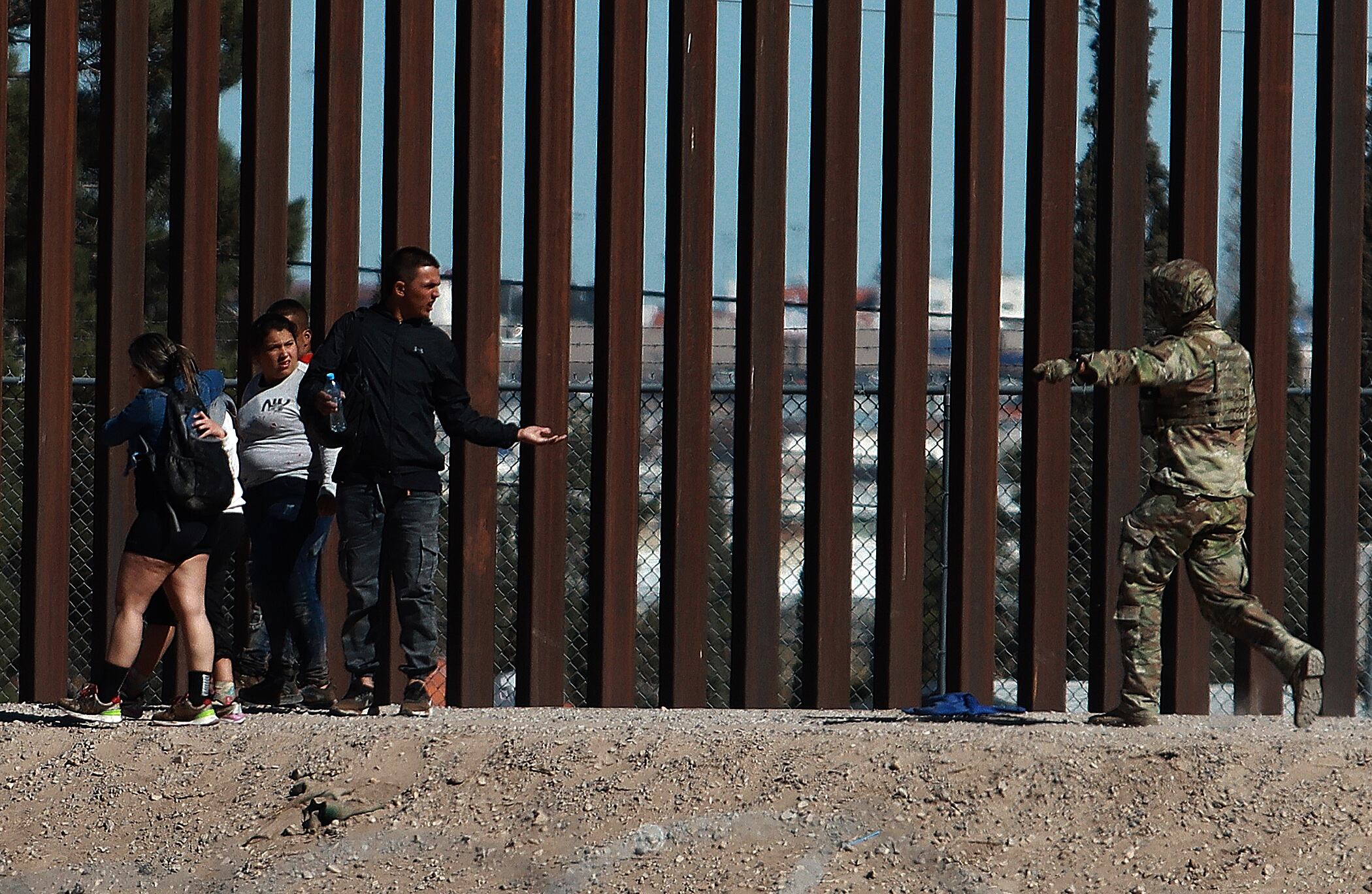 -FOTODELDÍA- MEX8736. CIUDAD JUÁREZ (MÉXICO), 18/02/2024.- Integrantes de la Guardia Nacional de Estados Unidos impide el avance de migrantes que intentan cruzar la frontera con México este domingo, en Ciudad Juárez, estado de Chihuahua (México). Activistas de Ciudad Juárez cuestionaron ESTE DOMINGO el hecho de que la Guardia Nacional de Texas expulsó a empujones a un grupo de migrantes que ya habían cruzado a Estados Unidos, y después agredieron a la prensa que documentaba el hecho desde el lado mexicano, apuntando con un rayo láser a los ojos y a las cámaras de varios periodistas. EFE/Luis Torres
