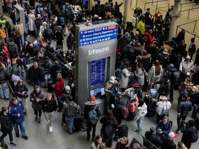 Los viajeros se agolpan frente a la zona de salidas internacionales de la estación de St. Pancras en Londres el 30 de diciembre de 2025, tras la suspensión del servicio de trenes Eurostar entre Gran Bretaña y Europa continental. Eurostar aconsejó a los pasajeros que pospusieran sus viajes del 30 de diciembre, alegando "perturbaciones importantes", incluyendo graves retrasos y cancelaciones. (Foto de CARLOS JASSO / AFP)