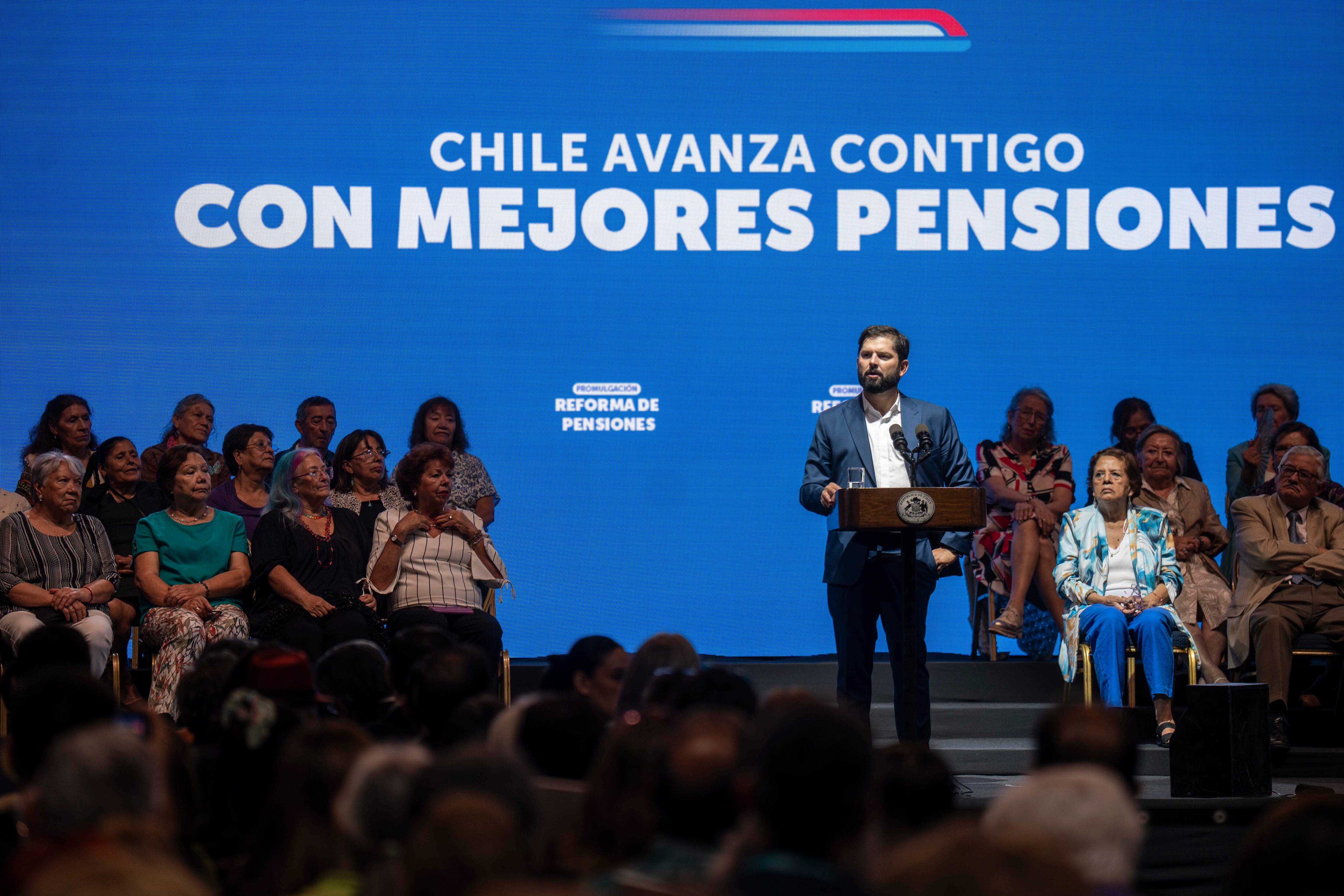 AME1030. SANTIAGO (CHILE), 20/03/2025.- Fotografía cedida por presidencia de Chile, del presidente Gabriel Boric (c), hablando durante la actividad en la que promulgó la reforma de pensiones este jueves, en Santiago (Chile). Boric divulgó su emblemática reforma de pensiones, proyecto que beneficiará a más de 2,8 millones de personas y que supone el mayor cambio en 40 años al modelo creado durante la dictadura de Augusto Pinochet (1973-1990). EFE/ Presidencia de Chile /SOLO USO EDITORIAL/NO VENTAS/SOLO DISPONIBLE PARA ILUSTRAR LA NOTICIA QUE ACOMPAÑA (CRÉDITO OBLIGATORIO)