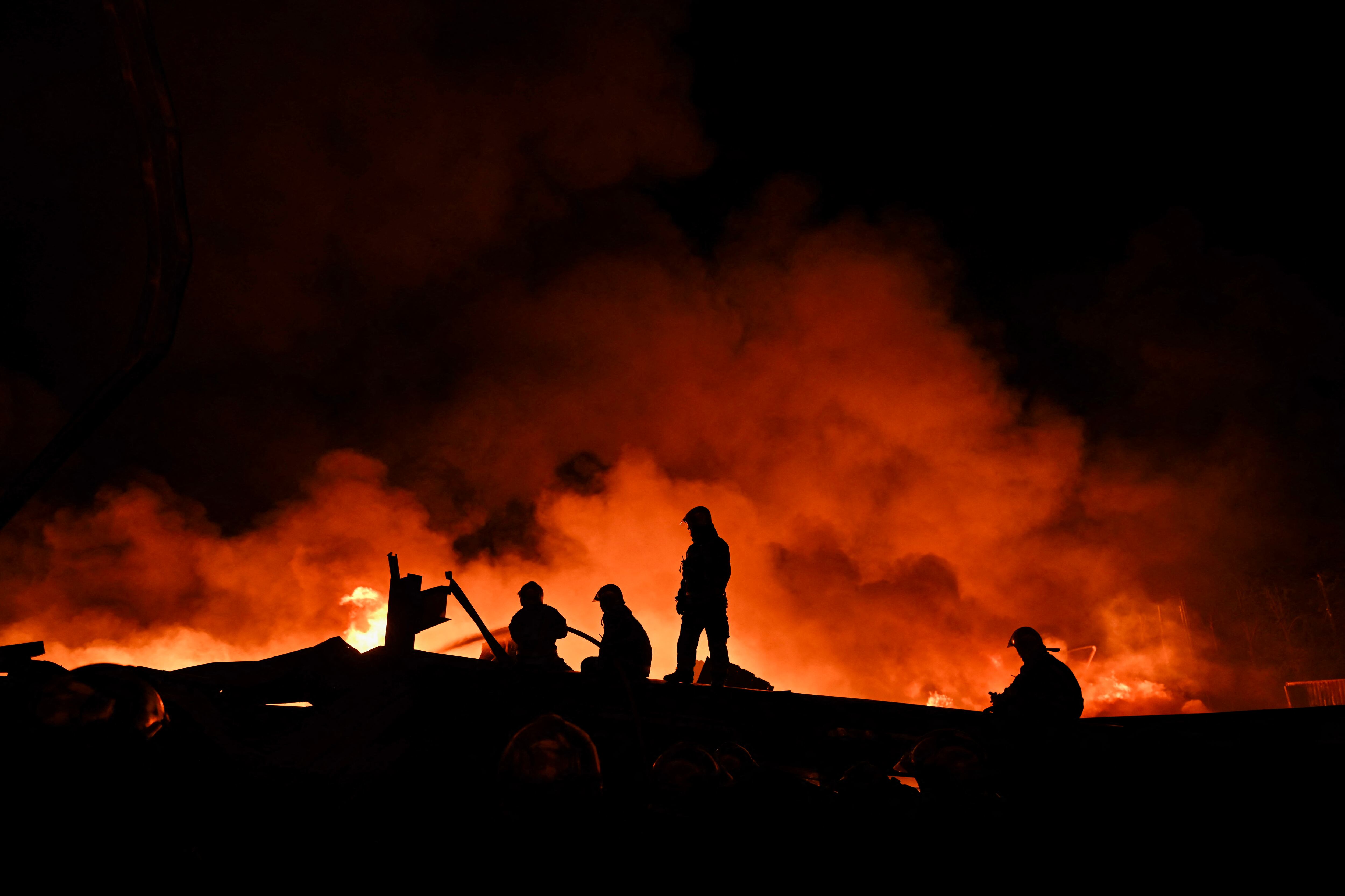 Firefighters work to extinguish a fire after an explosion in an industrial area of Ezeiza, Buenos Aires province, Argentina on November 15, 2025. Powerful explosions rocked an industrial area and ignited a fire south of Buenos Aires on the night of November 14, 2025, officials said, with at least 22 people sent to the hospital. (Photo by Luis ROBAYO / AFP)