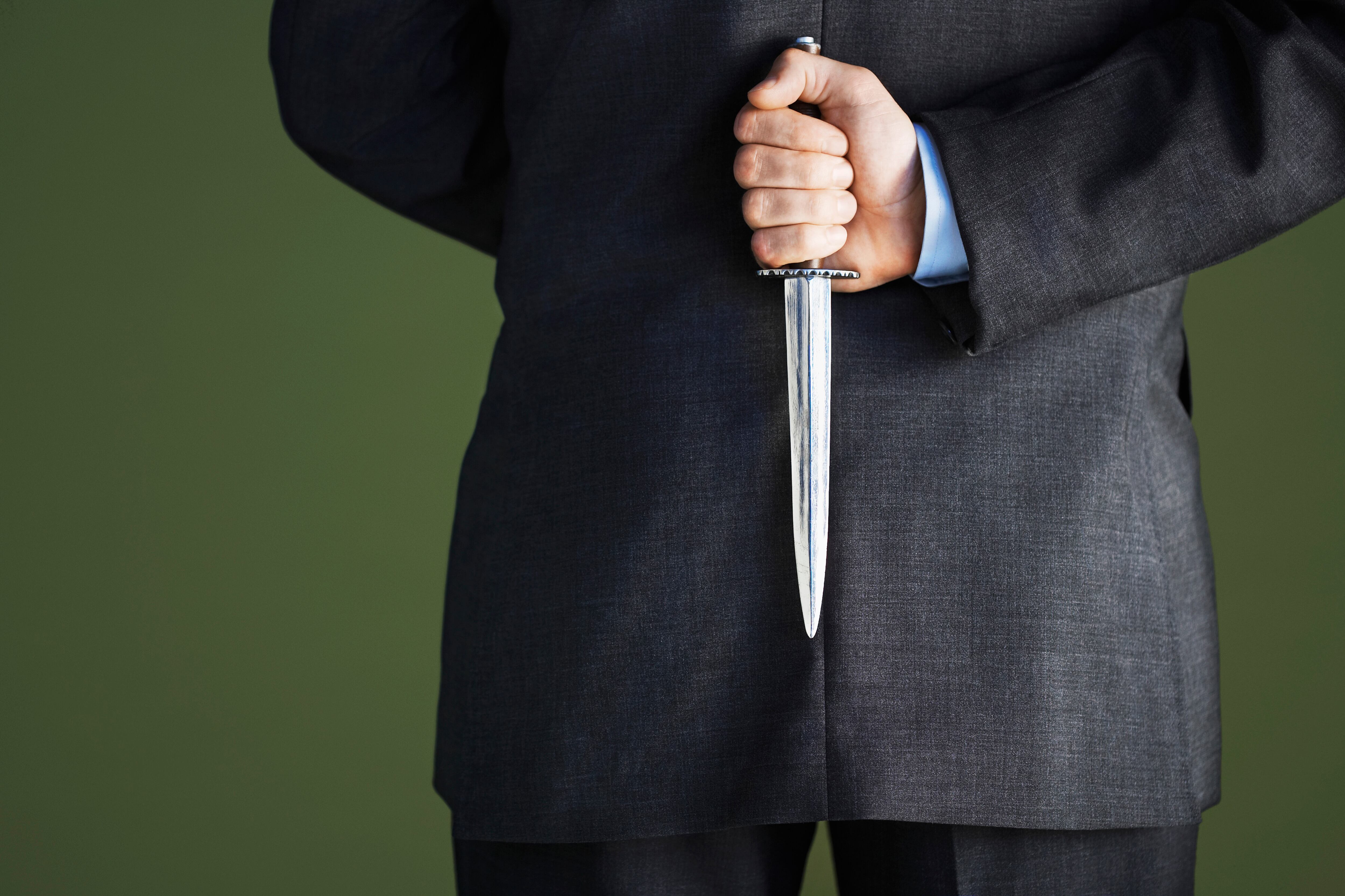 Businessman Holding Knife Behind Back