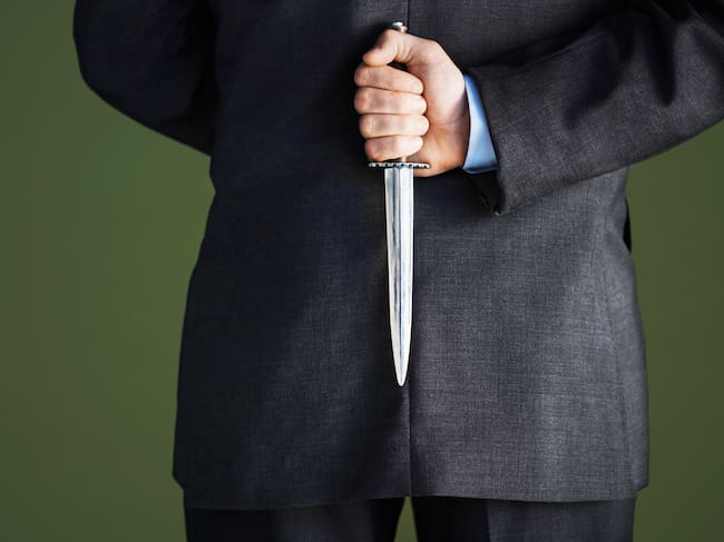 Businessman Holding Knife Behind Back