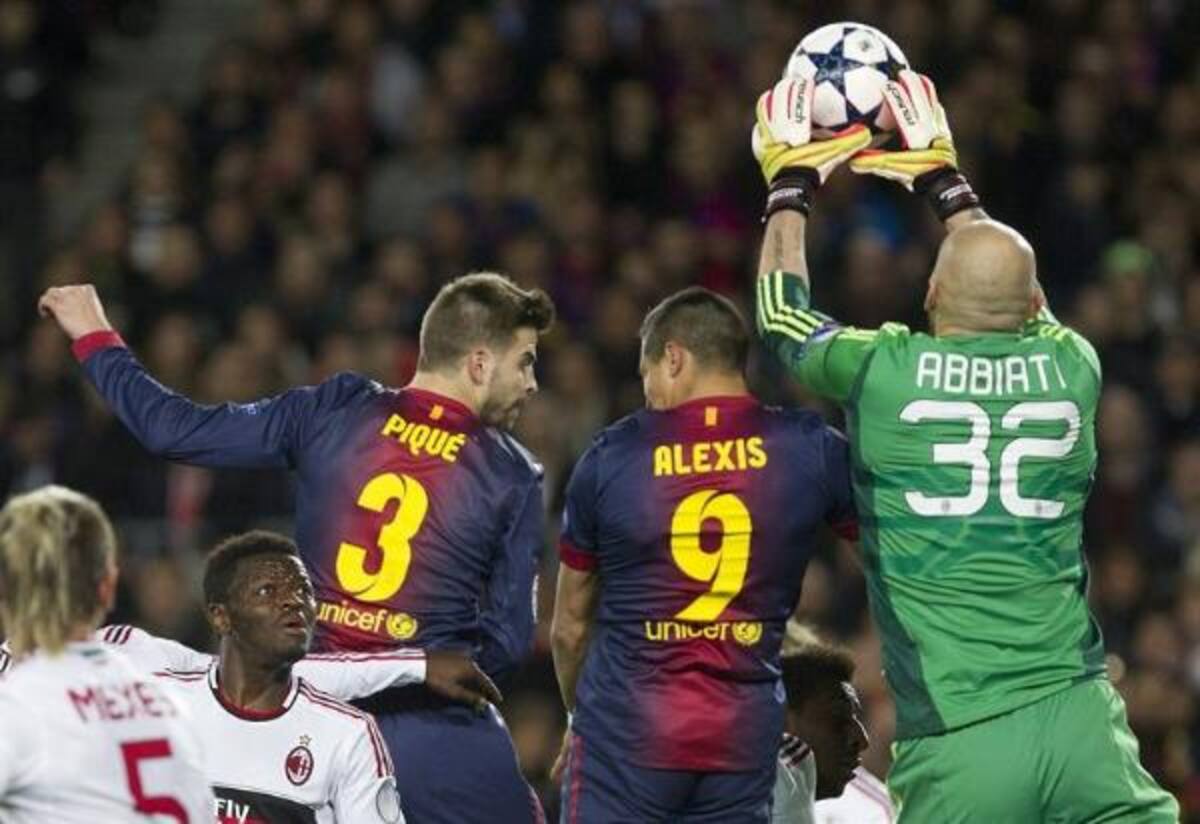 El portero del Milan Abbiati detiene un balón ante Gerard Piqué y el chileno Alexis Sánchez.