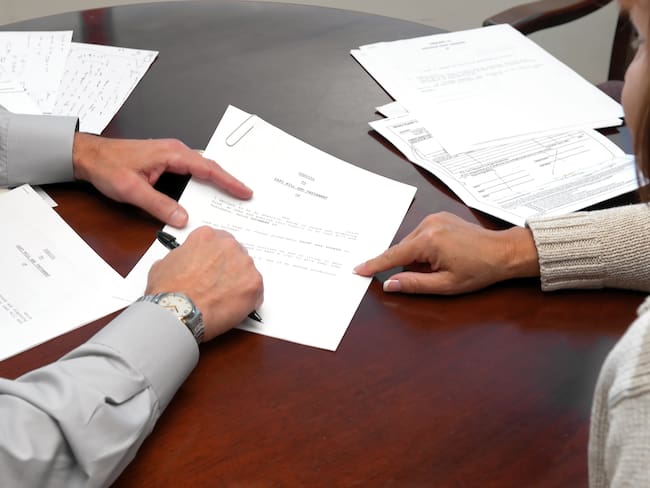 Mujer presentando su testamento ante un notario (Foto vía GettyImages)