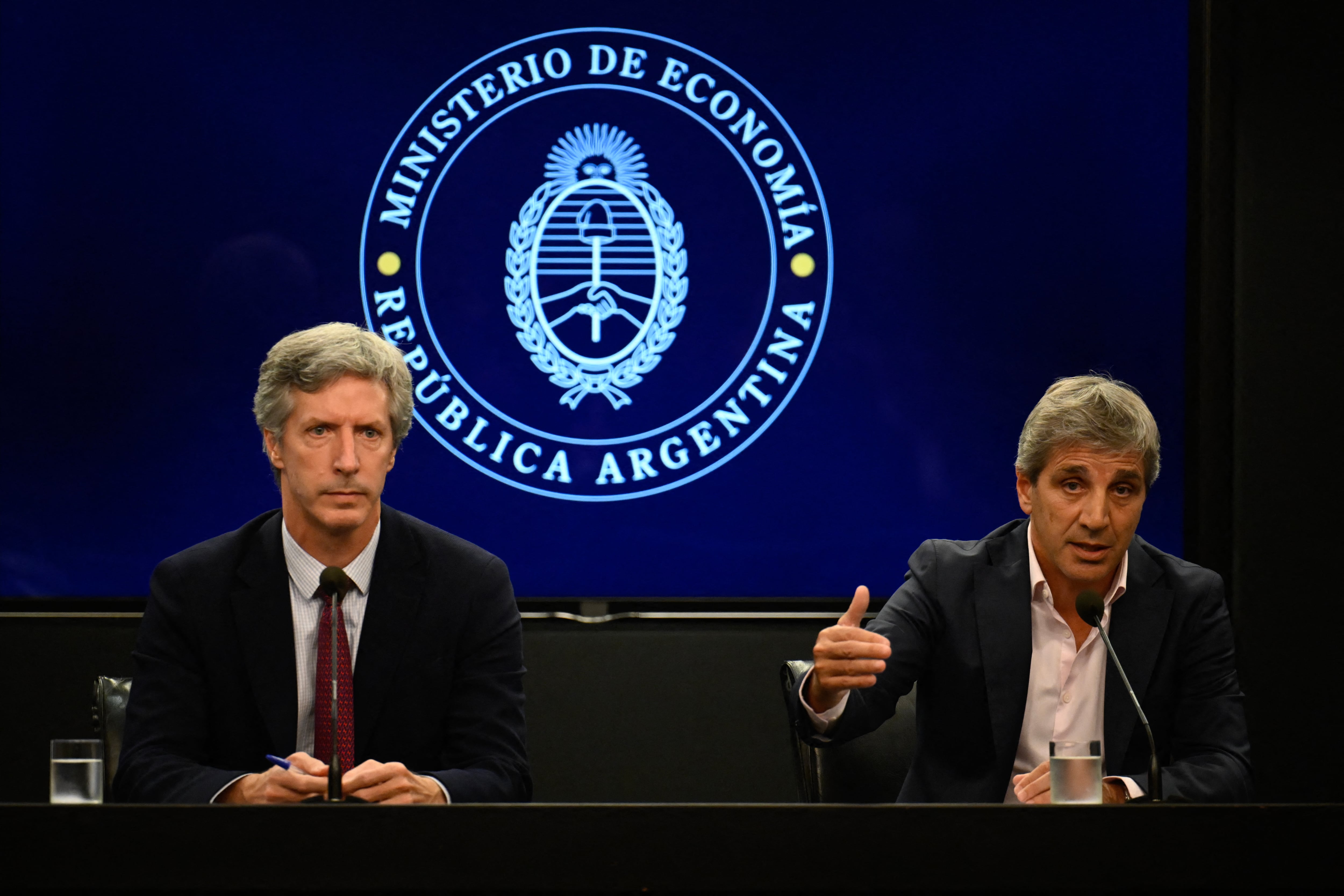 Economy Minister Luis Caputo (R), accompanied by the President of the Central Bank of Argentina Santiago Bausili (L), speaks during a press conference about the agreement made between Argentina and the International Monetary Fund, at the Economy Ministry headquarters in Buenos Aires on January 10, 2024. Argentina and the IMF announced this Wednesday an agreement at a technical level, subject to the approval of the organization's board of directors, for the disbursement of 4.7 billion dollars to the South American country within the framework of its credit program with the financial institution. (Photo by Luis ROBAYO / AFP) (Photo by LUIS ROBAYO/AFP via Getty Images)