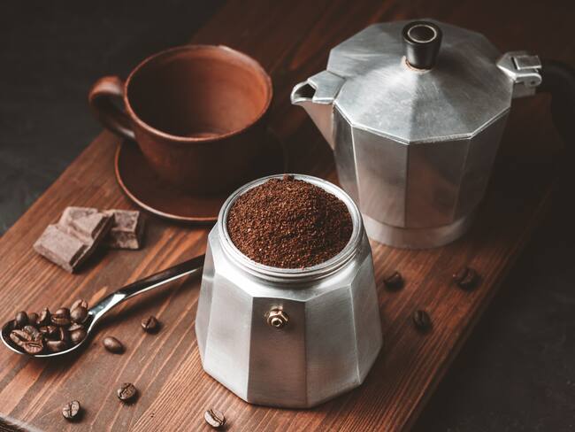Cafetera italiana llena de café molido marrón sobre una tabla oscura (Foto vía Getty Images)