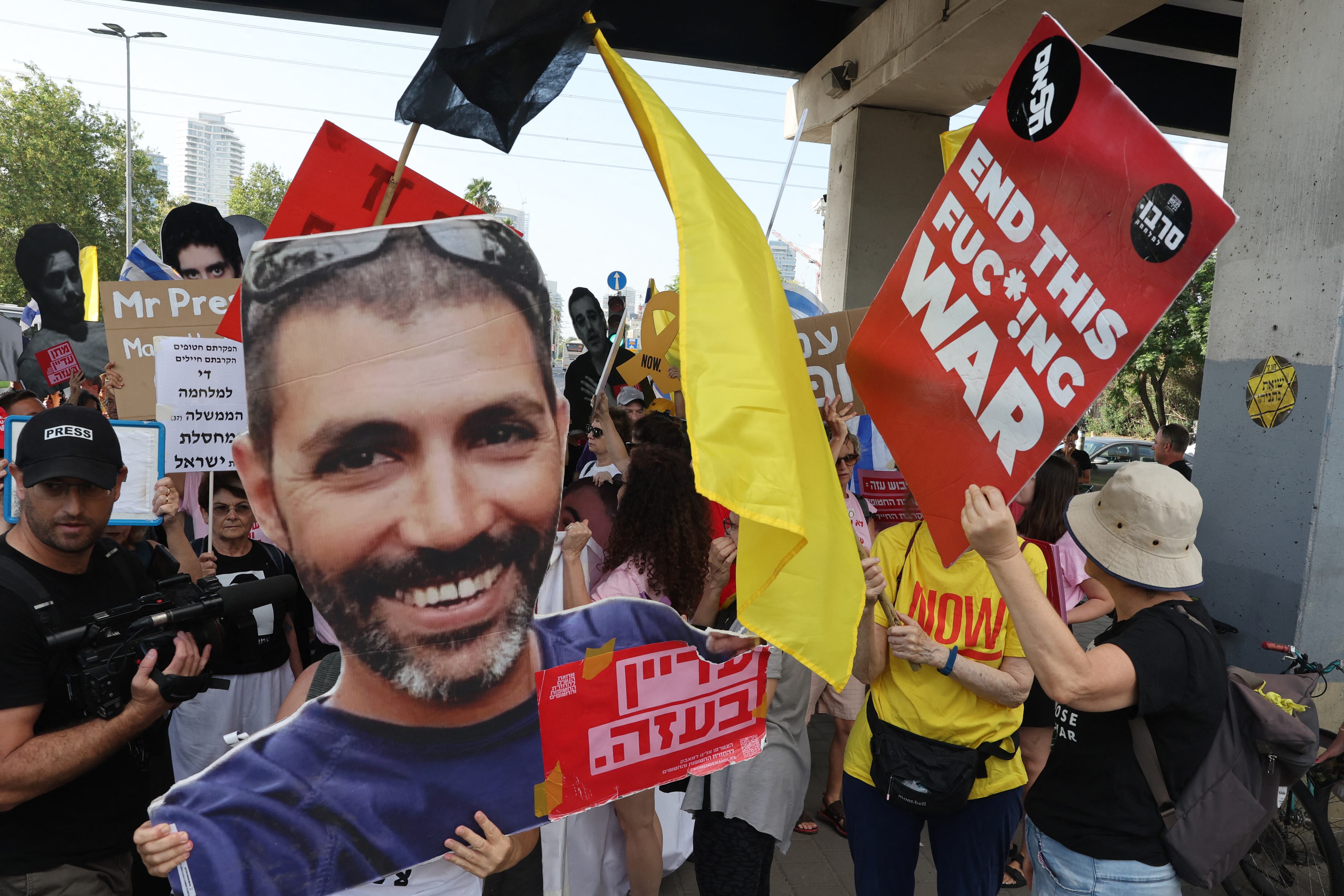Protesters gather with signs during a demonstration organised by the families of the Israeli hostages taken captive in the Gaza Strip since the October 2023 calling for action to secure their release and a ceasefire in the war against Hamas in Tel Aviv on August 26, 2025. (Photo by Jack GUEZ / AFP)
