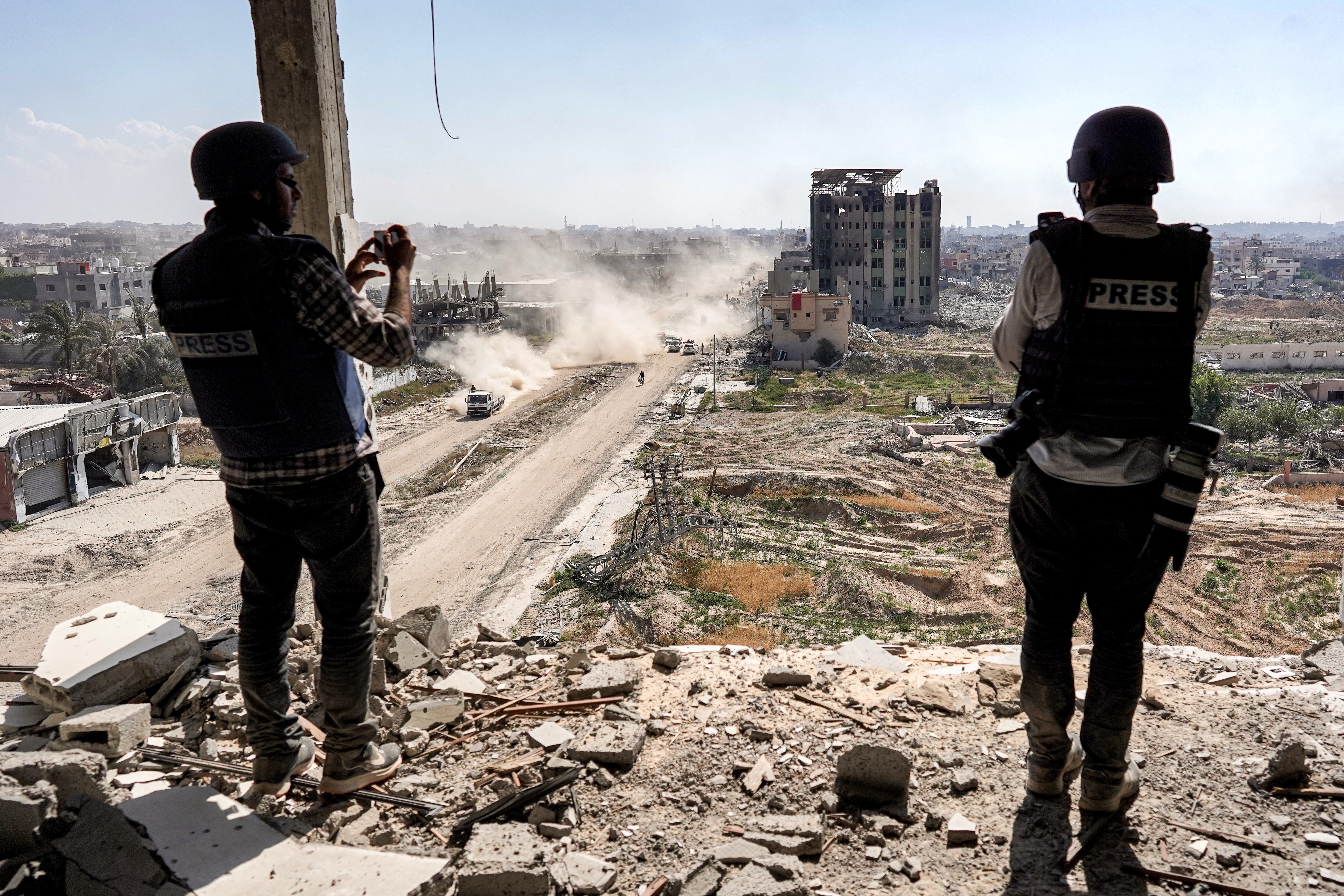 Journalists film from atop a damaged building facing the ravaged building of al-Salam hospital in Khan Yunis on April 7, 2024.