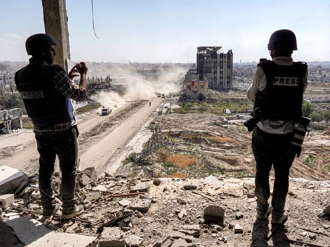 Journalists film from atop a damaged building facing the ravaged building of al-Salam hospital in Khan Yunis on April 7, 2024.