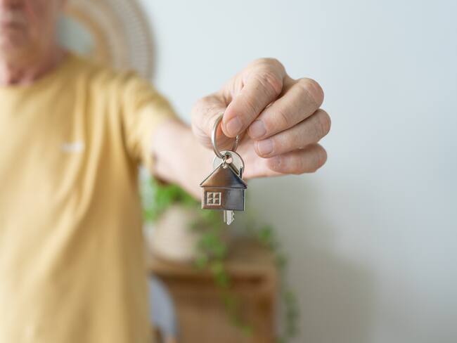 Persona entregando las llaves de una vivienda (Foto vía Getty Images)