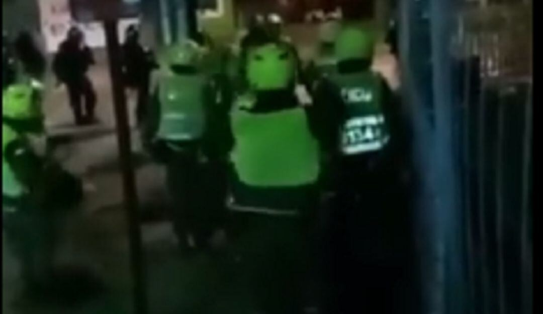 Momento en el que uno de los uniformados se cambia el chaleco y lo usa al revés