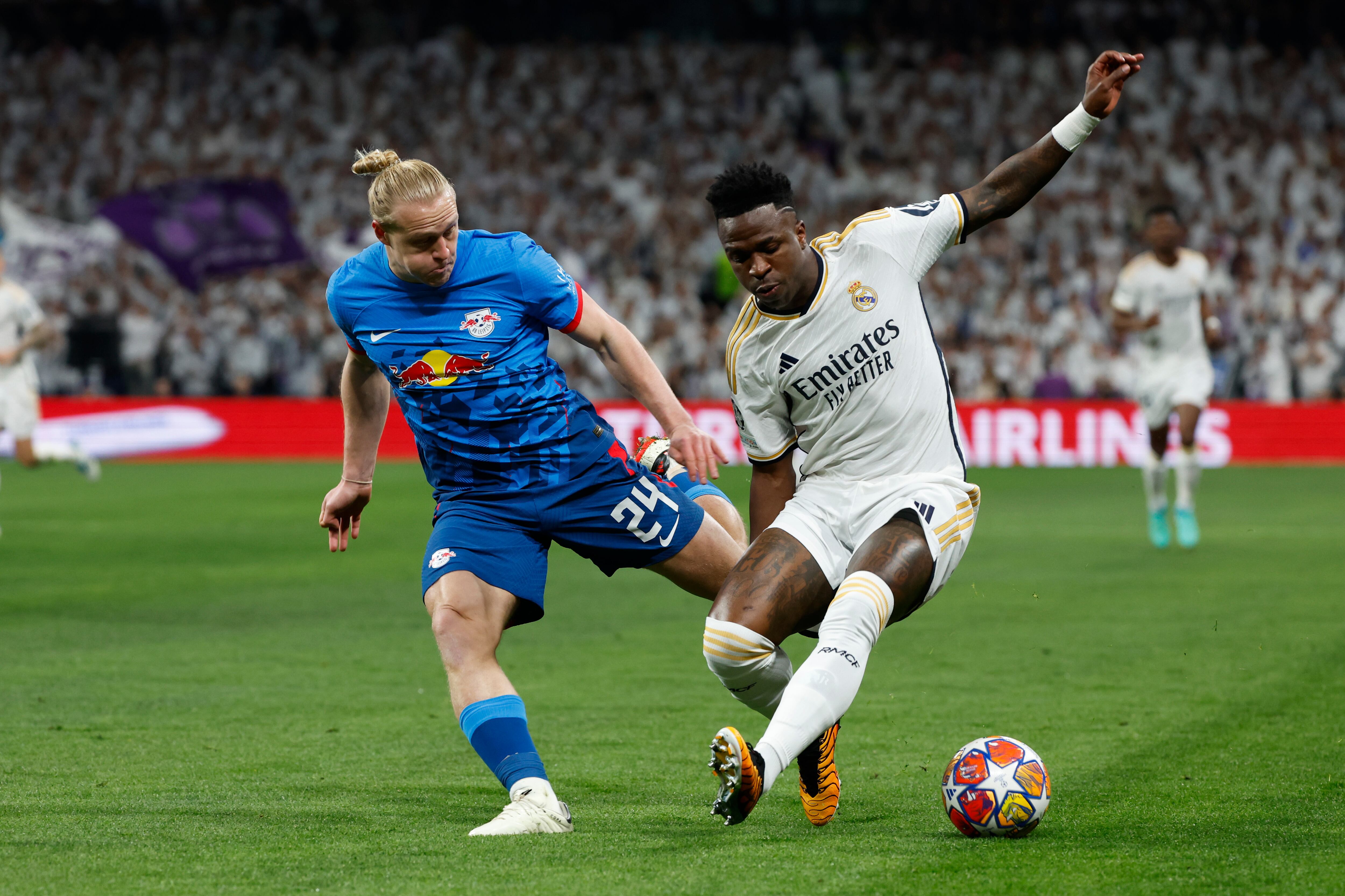 MADRID, 06/03/2024.- El delantero brasileño del Real Madrid Vinicius Junior (d) pelea un balón con el centrocampista austriaco del Leipzig Xavier Schlager durante el partido de vuelta de los octavos de final de la Liga de Campeones que Real Madrid y RB Leipzig disputan este miércoles en el estadio Santiago Bernabéu. EFE/JJ Guillén