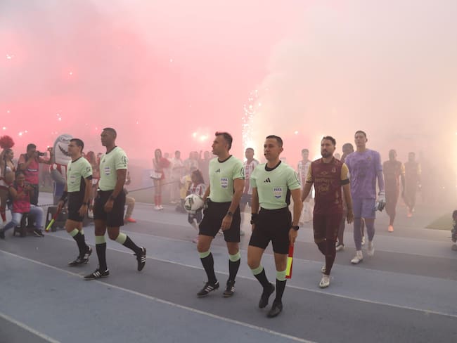 Junior y Tolima ingresan al terreno de juego del estadio Metropolitano en medio de la pirotecnia de los aficionados locales / Colprensa.