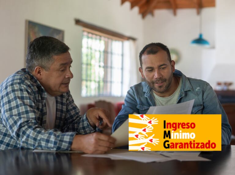 Personas revisando Ingreso Mínimo Garantizado (Getty Images)