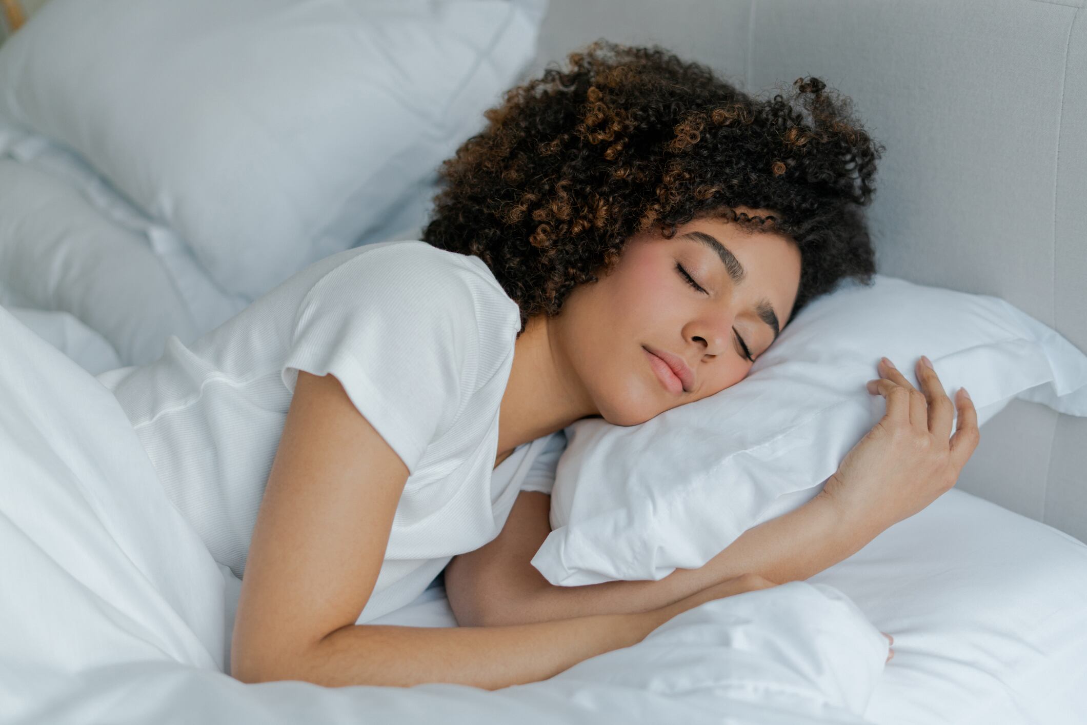 Mujer durmiendo boca abajo con la almohada. Cortesía Getty