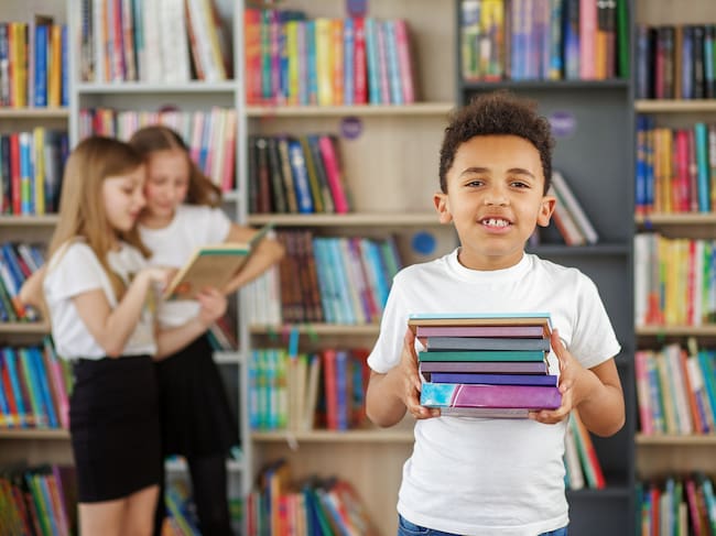Concept of studying, back to school and education. Child schoolboy reading book in library or bookstore.