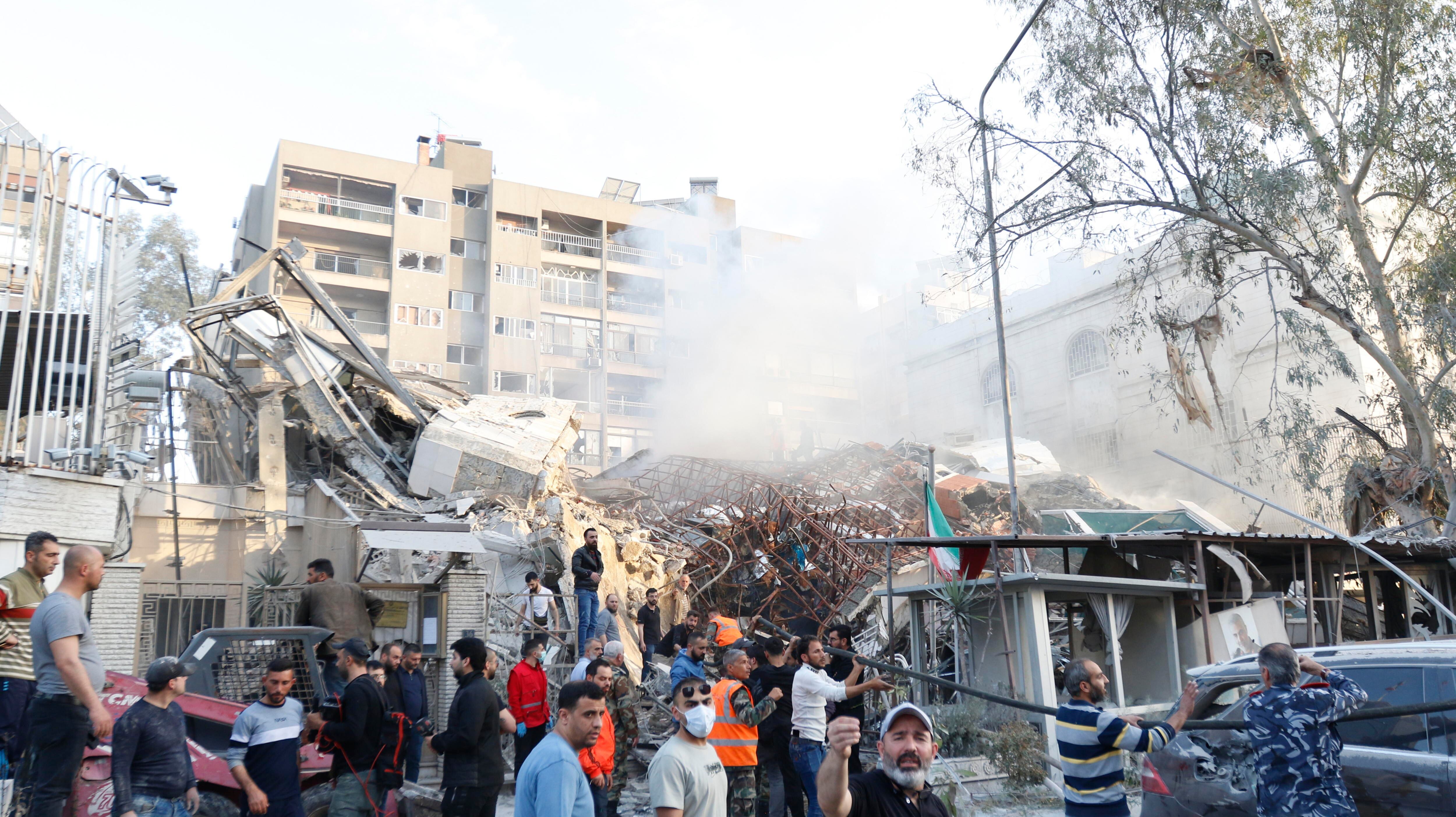 Damascus (Syrian Arab Republic), 01/04/2024.- Rescue workers and bystanders at the site of an airstrike in Damascus, Syria, 01 April 2024. According to the Syrian Arab News Agency SANA, Israel on 01 April launched an airstrike targeting the Iranian consulate building in Damascus. The consulate was damaged while the building next to it was destroyed. (Siria, Damasco) EFE/EPA/YOUSSEF DAFAWWI