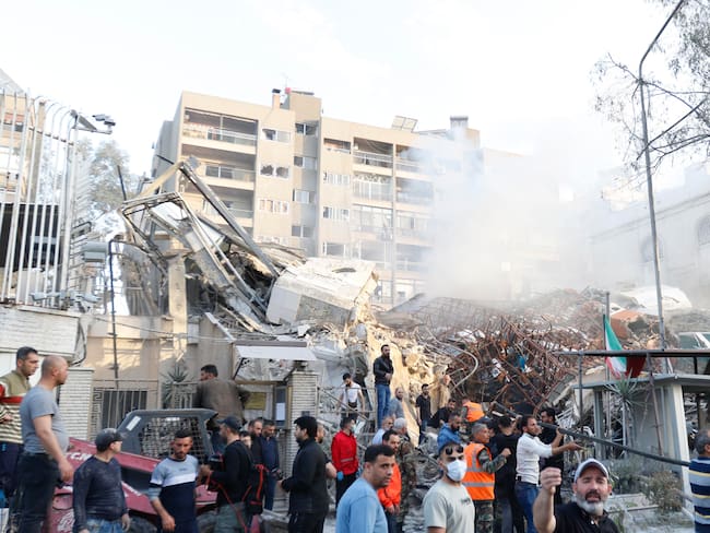 Damascus (Syrian Arab Republic), 01/04/2024.- Rescue workers and bystanders at the site of an airstrike in Damascus, Syria, 01 April 2024. According to the Syrian Arab News Agency SANA, Israel on 01 April launched an airstrike targeting the Iranian consulate building in Damascus. The consulate was damaged while the building next to it was destroyed. (Siria, Damasco) EFE/EPA/YOUSSEF DAFAWWI