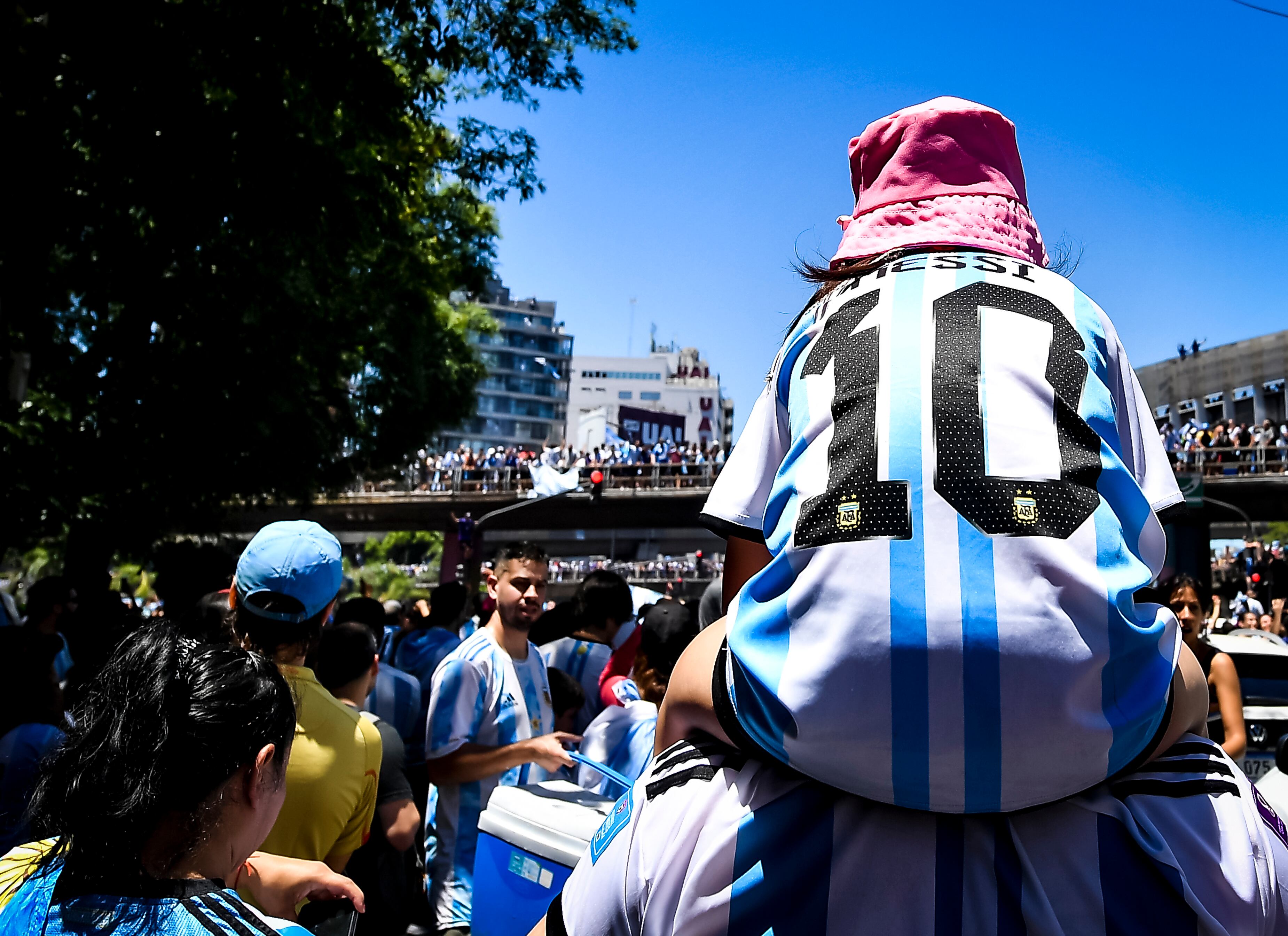 BUENOS AIRES, ARGENTINA - DECEMBER 20: A fan on Argentina wears a jersey of Lionel Messi as a multitude celebrate near 25 de Mayo highway for the victory parade of the Argentina men's national football team after winning the FIFA World Cup Qatar 2022 on December 20, 2022 in Buenos Aires, Argentina. (Photo by Marcelo Endelli/Getty Images)