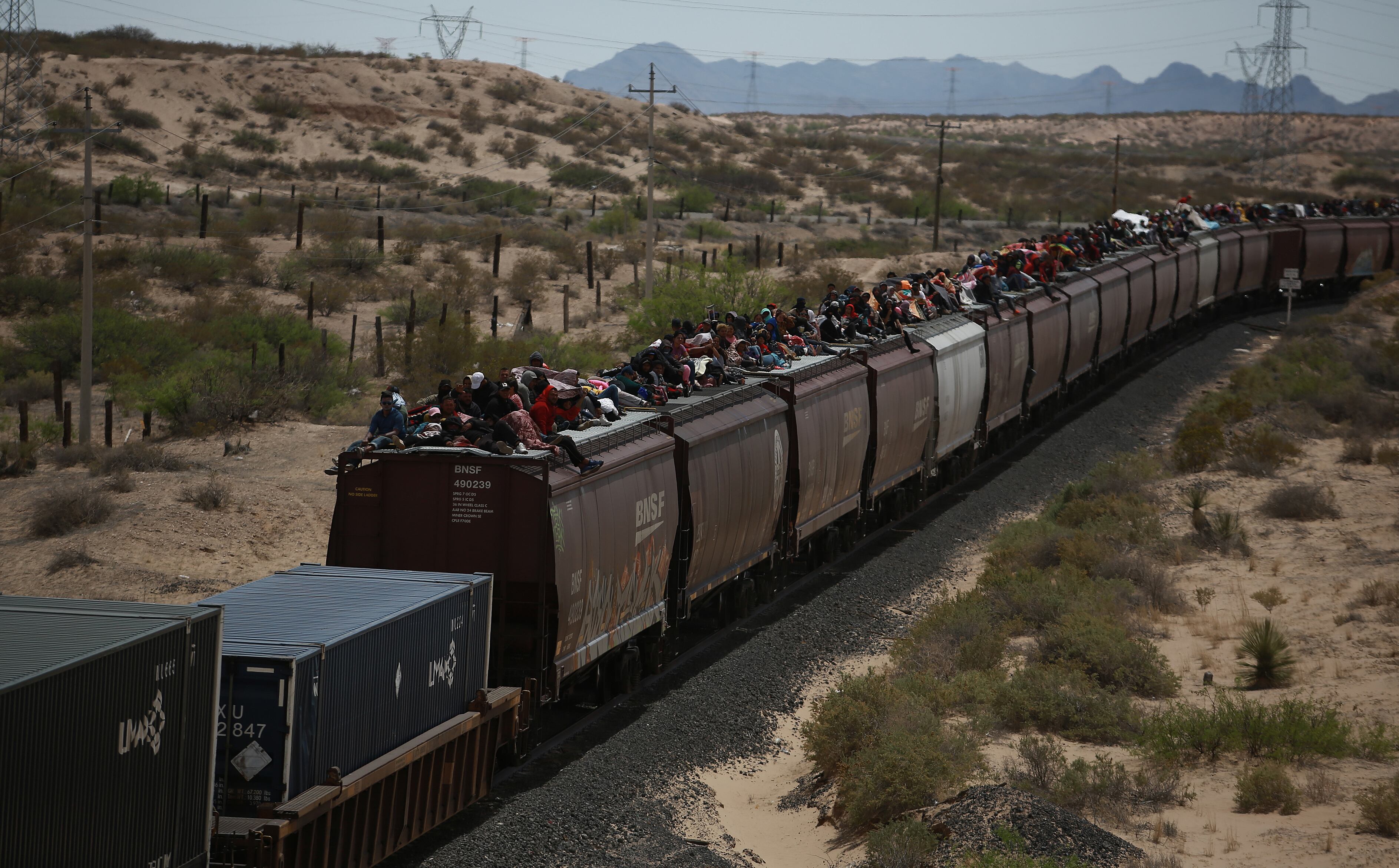 Migrantes viajan en el techo de un tren conocido como 'La bestia' en Ciudad Juárez (México). 
EFE/ Luis Torres
