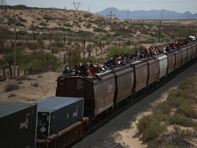 Migrantes viajan en el techo de un tren conocido como 'La bestia' en Ciudad Juárez (México).
EFE/ Luis Torres