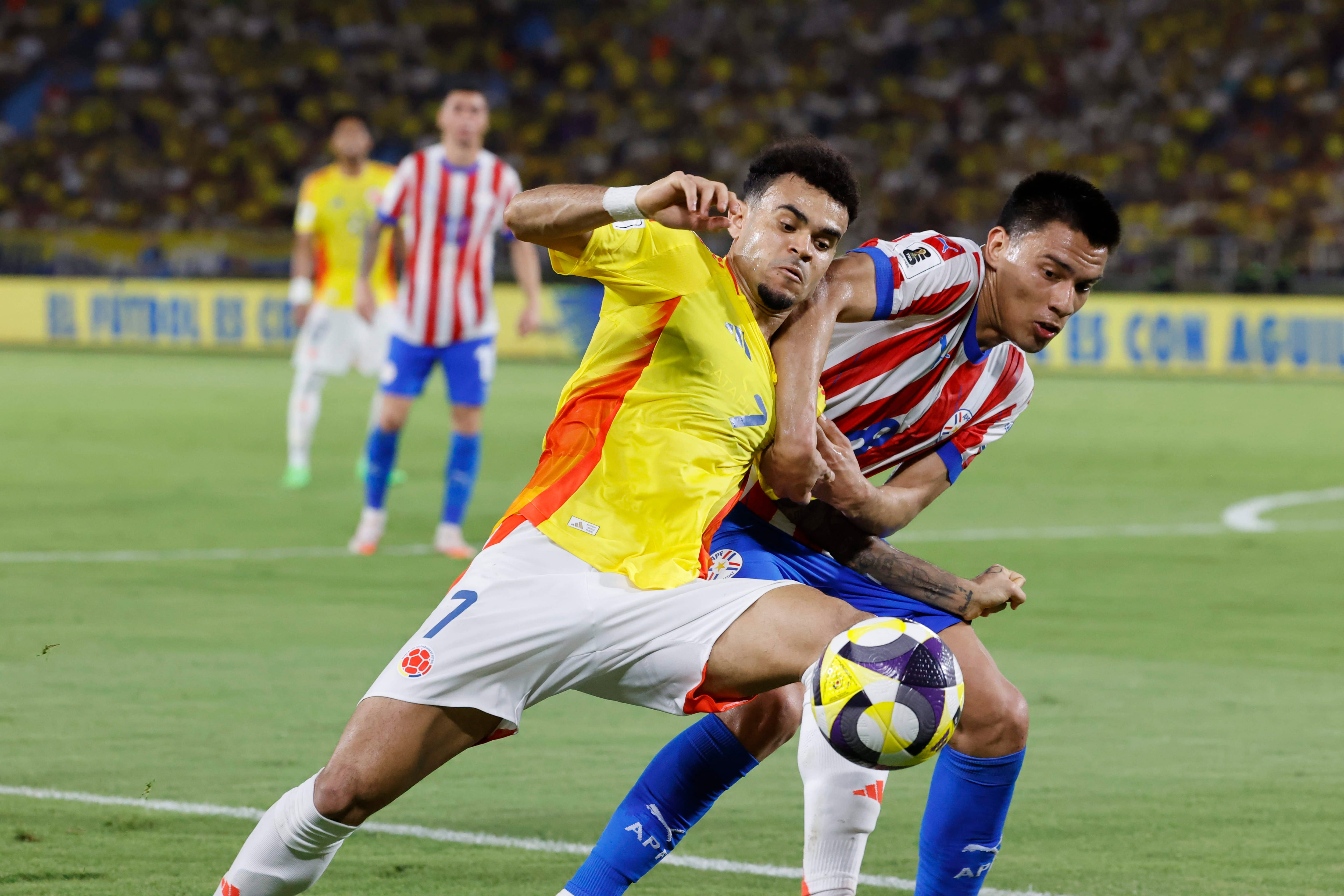 Luis Díaz (i) de Colombia disputa el balón con Diego Gómez de Paraguay este martes en un partido de las eliminatorias sudamericanas para el Mundial de 2026 entre las selecciones de Colombia y Paraguay en el estadio Metropolitano Roberto Meléndez en Barranquilla (Colombia). EFE/Mauricio Dueñas Castañeda