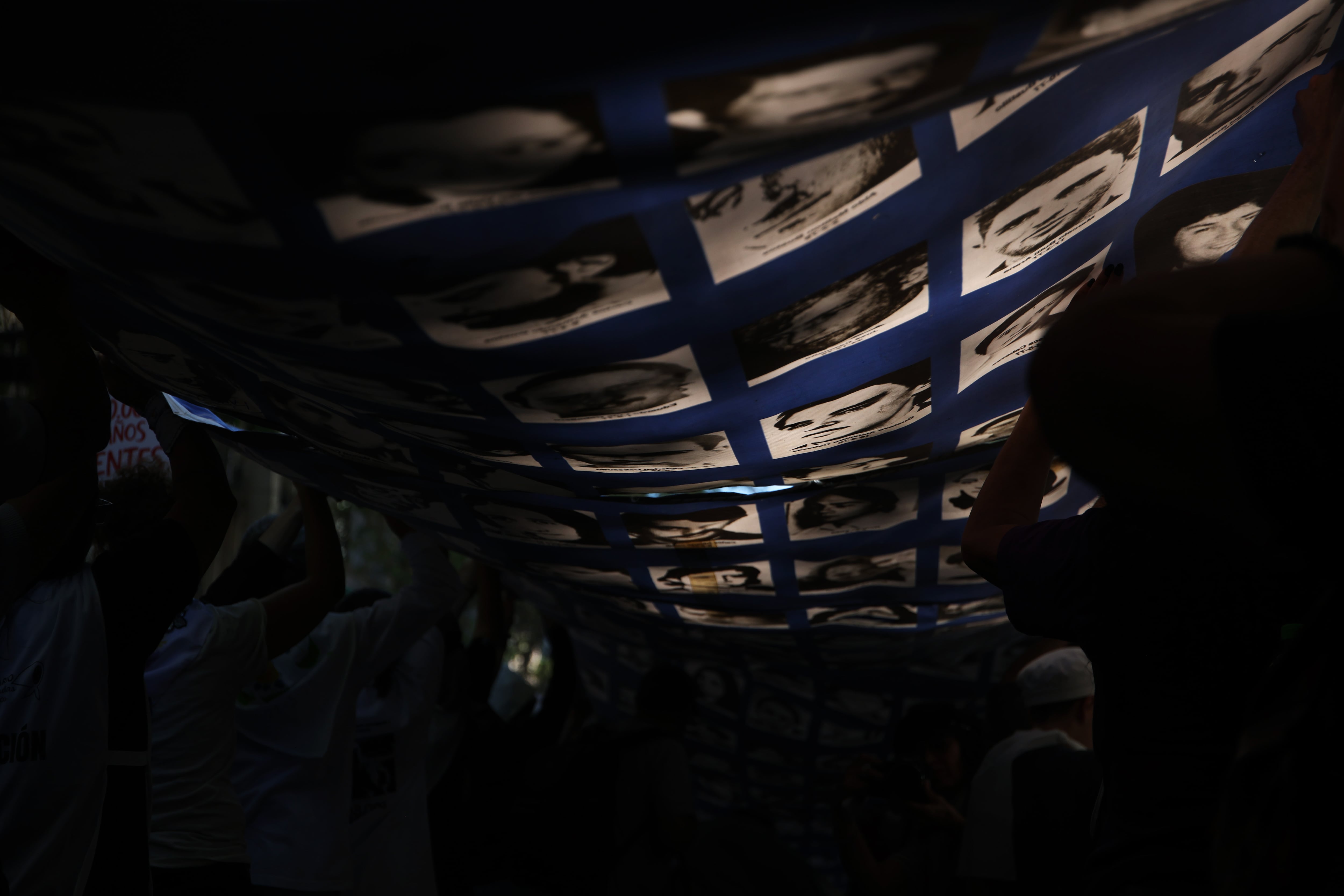Manifestantes en Argentina elevan una carpa gigante donde se muestran los rostros de los desaparecidos en medio de la dictadura.
(Foto:   Tobias Skarlovnik/Getty Images)